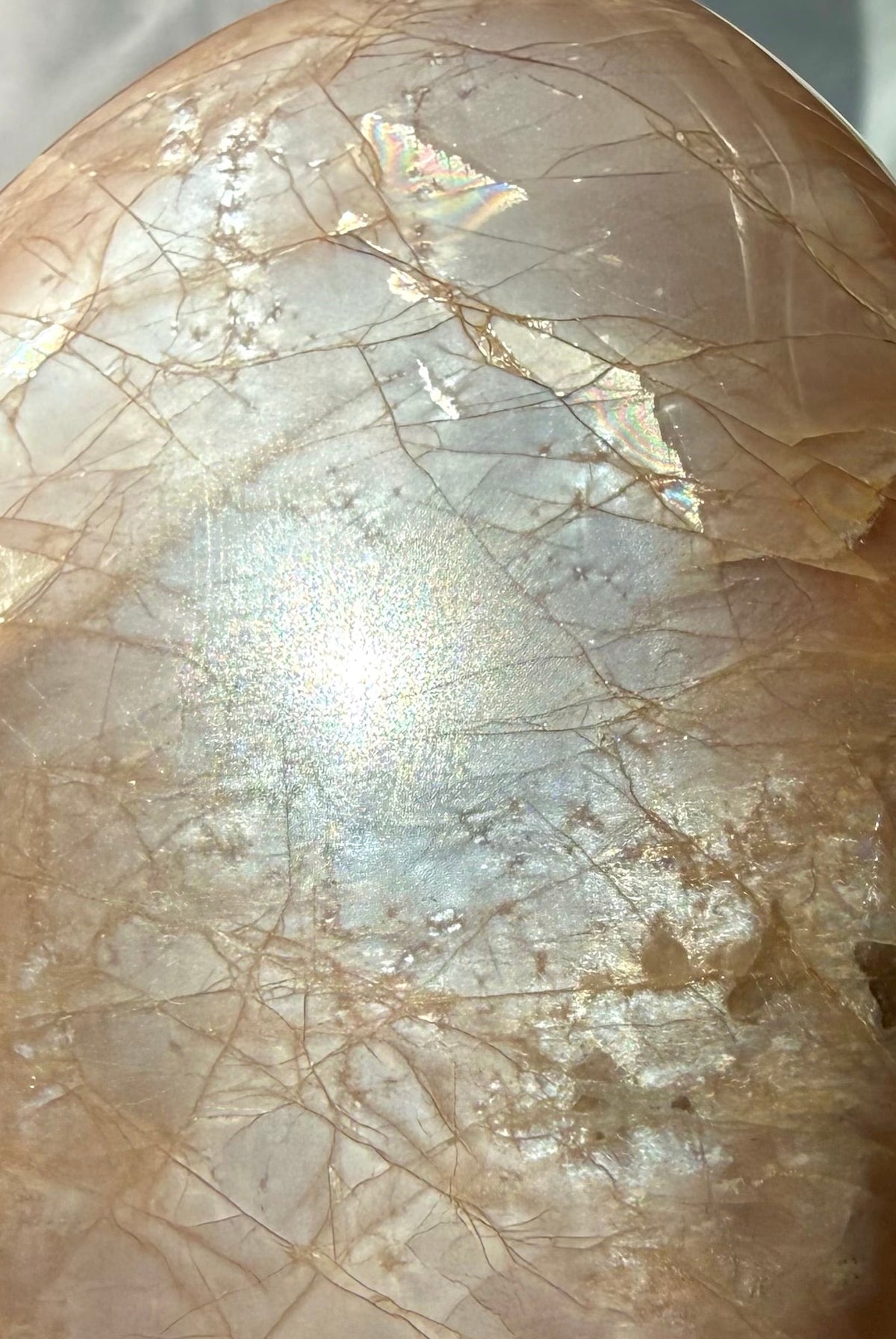 Close-up Peach Moonstone freeform showing luminous silver glow, golden Sunstone shimmer and warm peach feldspar tones