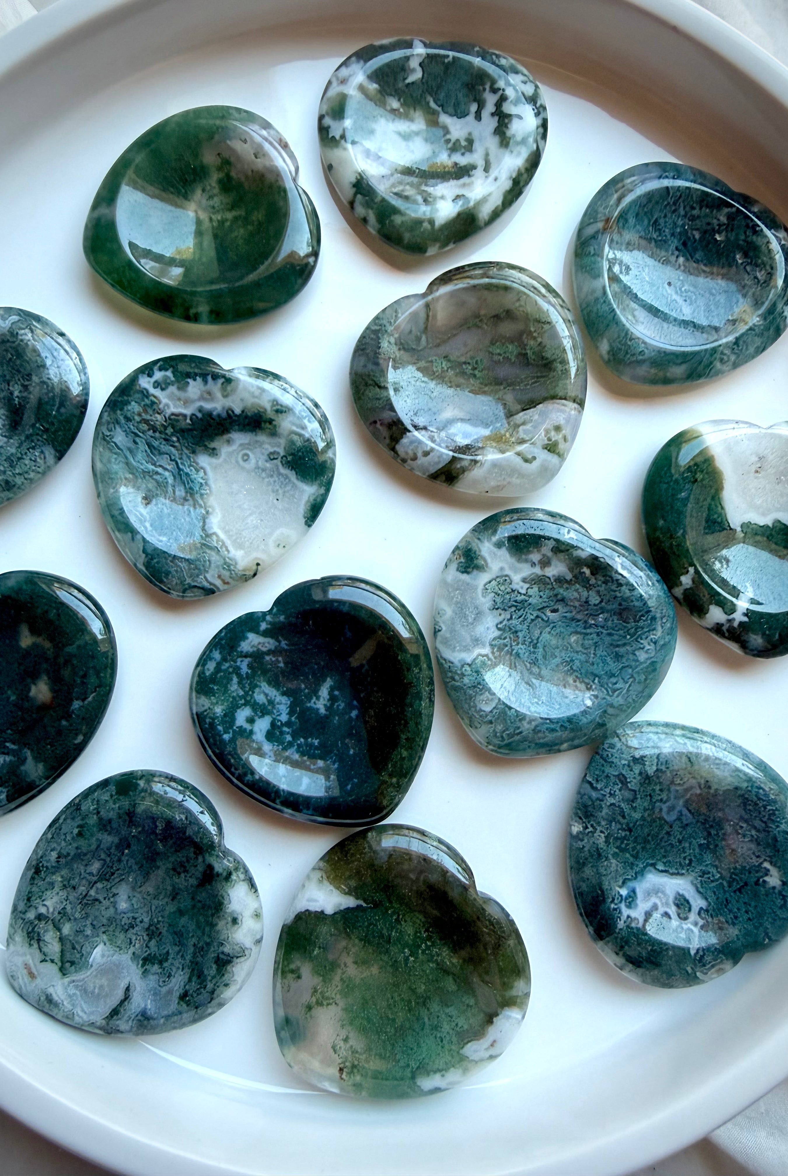 Assorted Moss Agate heart worry stones displaying unique green dendritic patterns and polished finish
