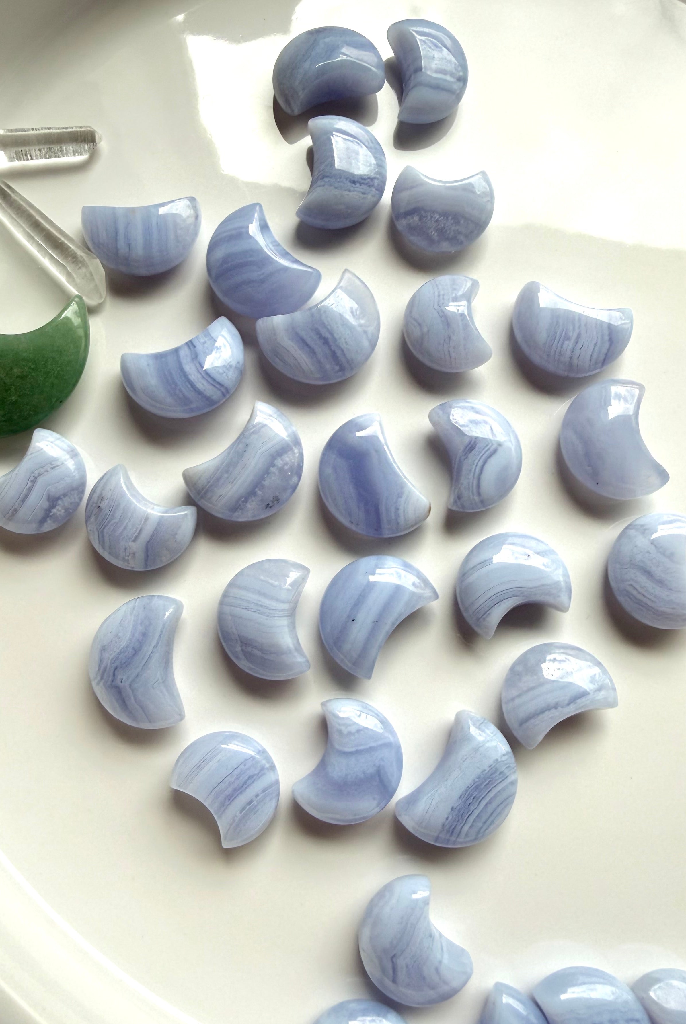 Blue Lace Agate crescent moon carvings in assorted sizes with soft blue color and natural white lace banding
