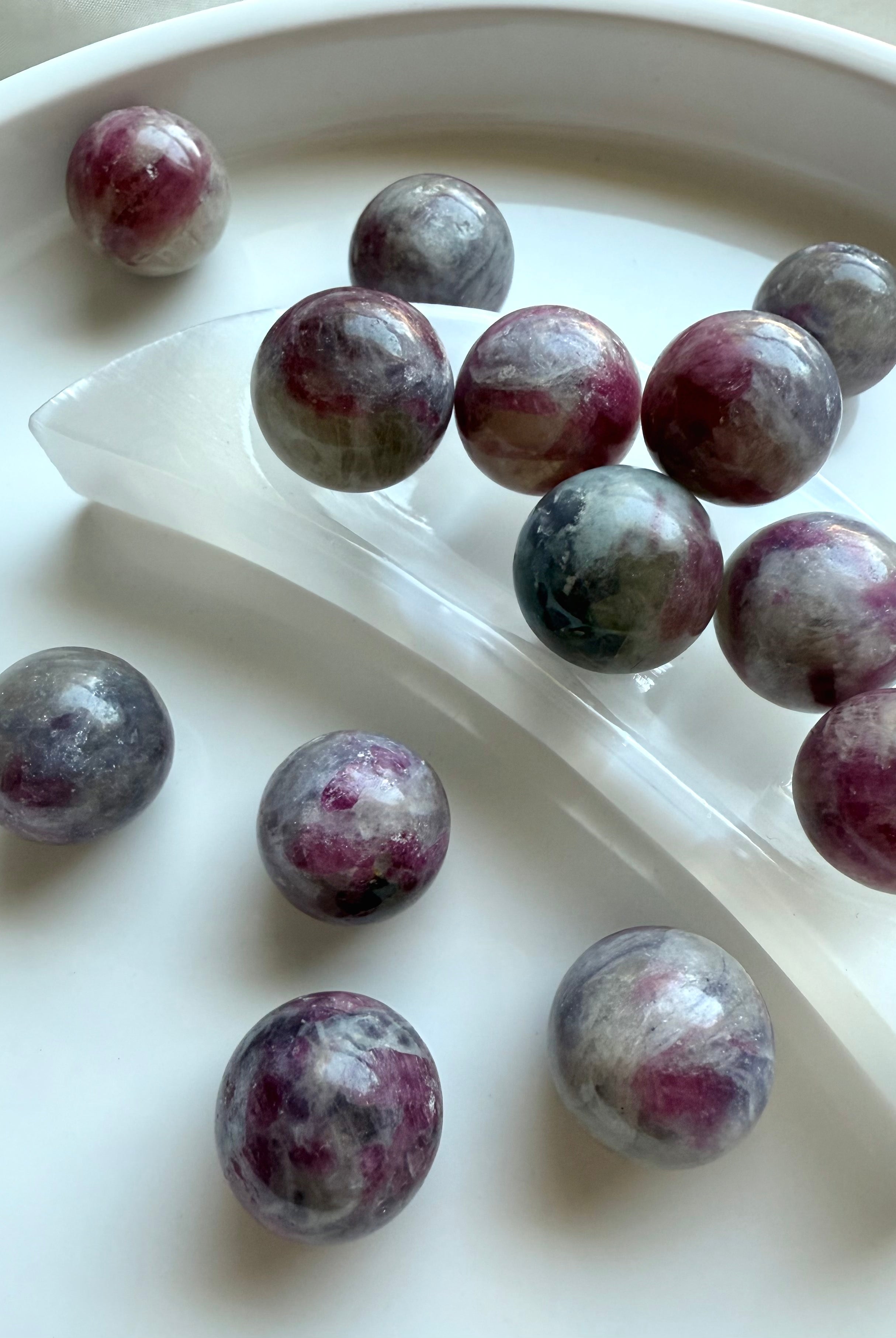 Mini Unicorn Stone crystal spheres displayed on a selenite crescent moon bowl for cleansing and charging