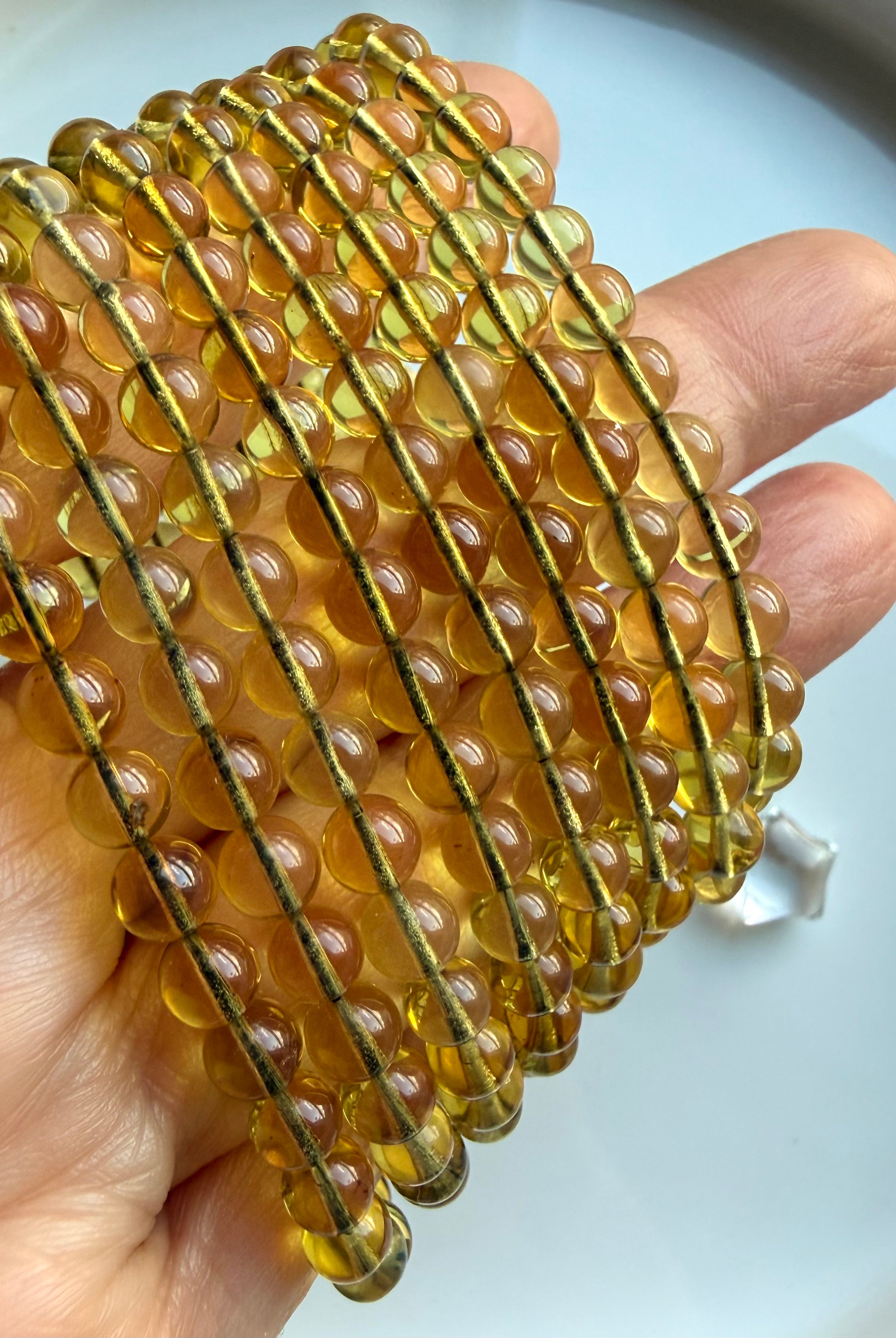 Stacked Indonesian blue amber bracelets showing translucent golden amber beads