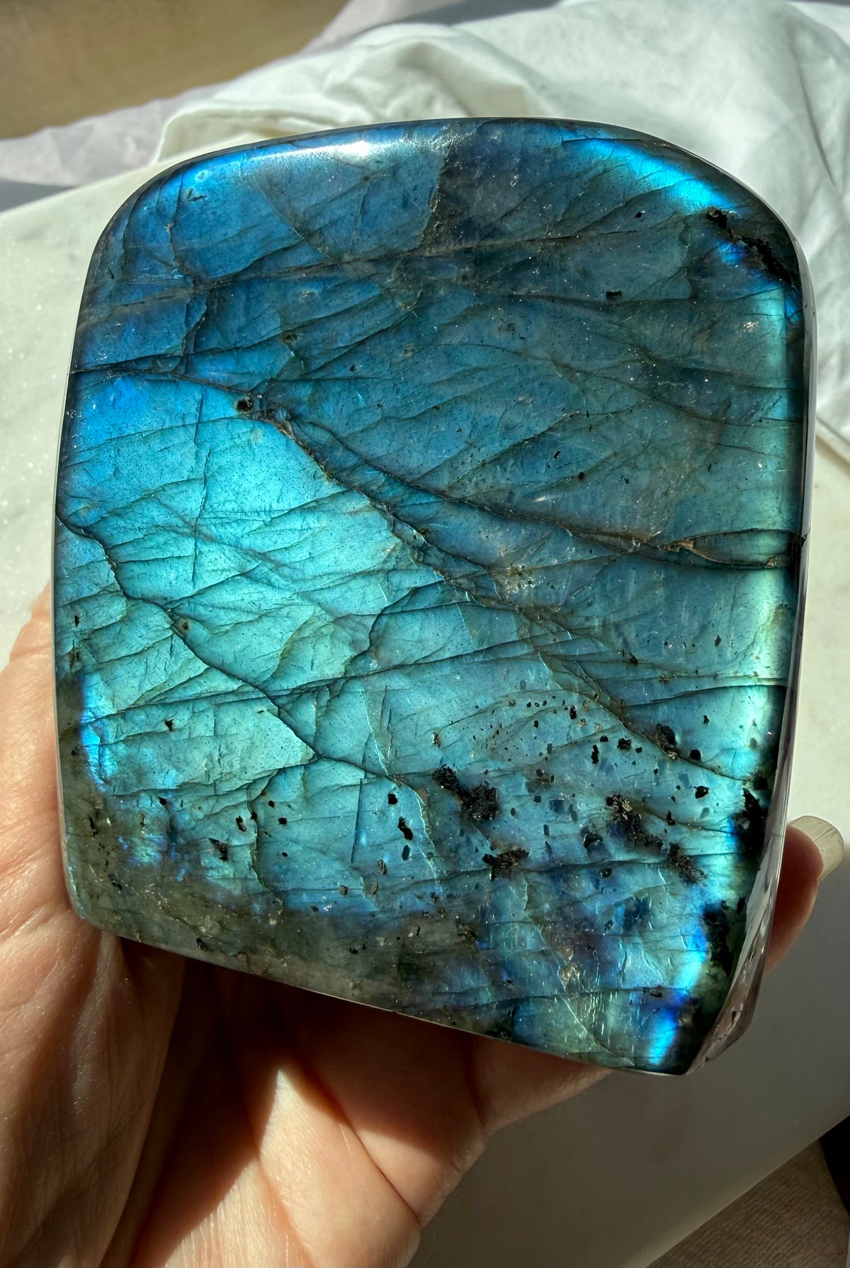 Blue flash Labradorite display crystal showing luminous aqua-blue color and natural internal patterns