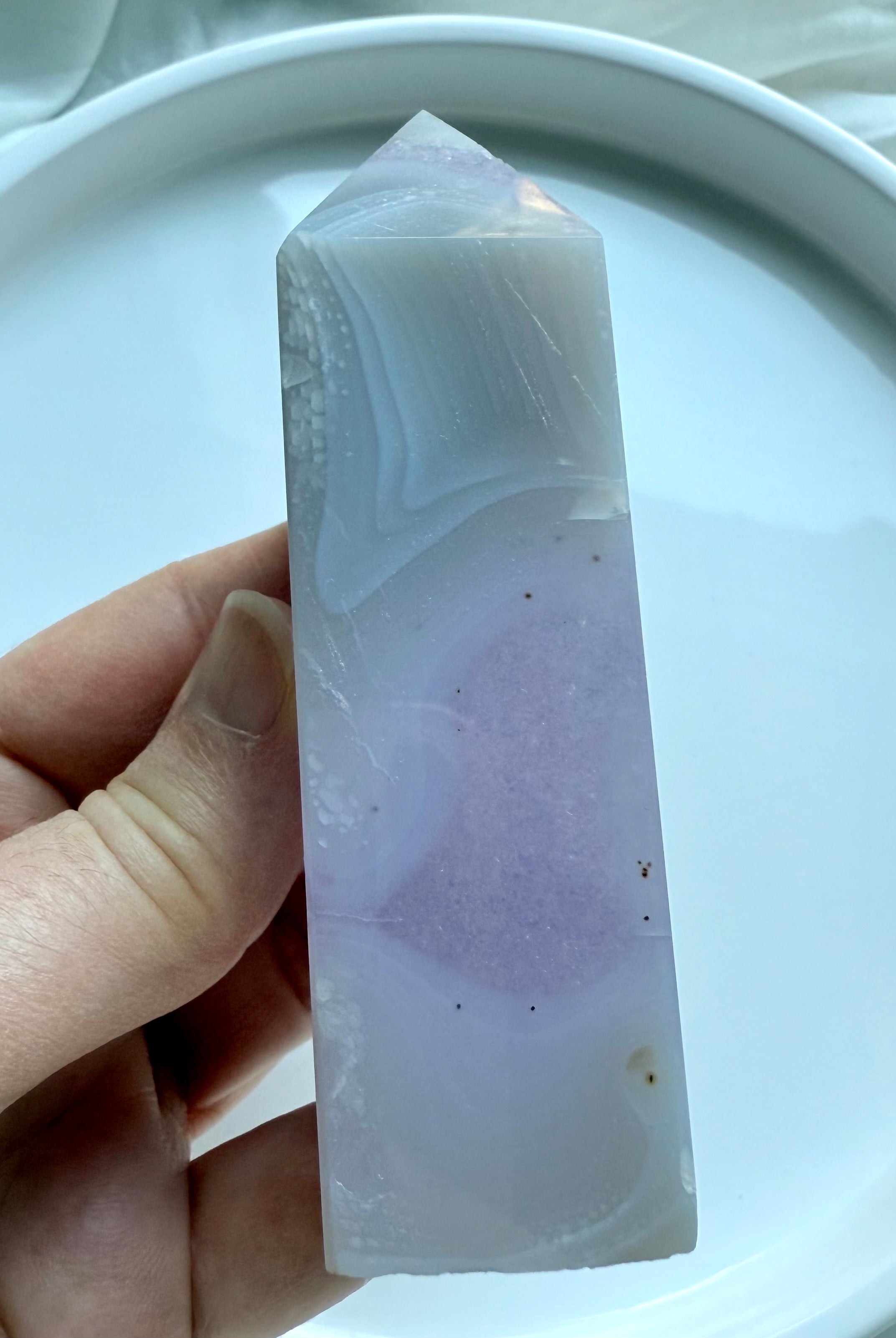 Close-up of polished Amethyst Tower with quartz inclusion and soft purple hues