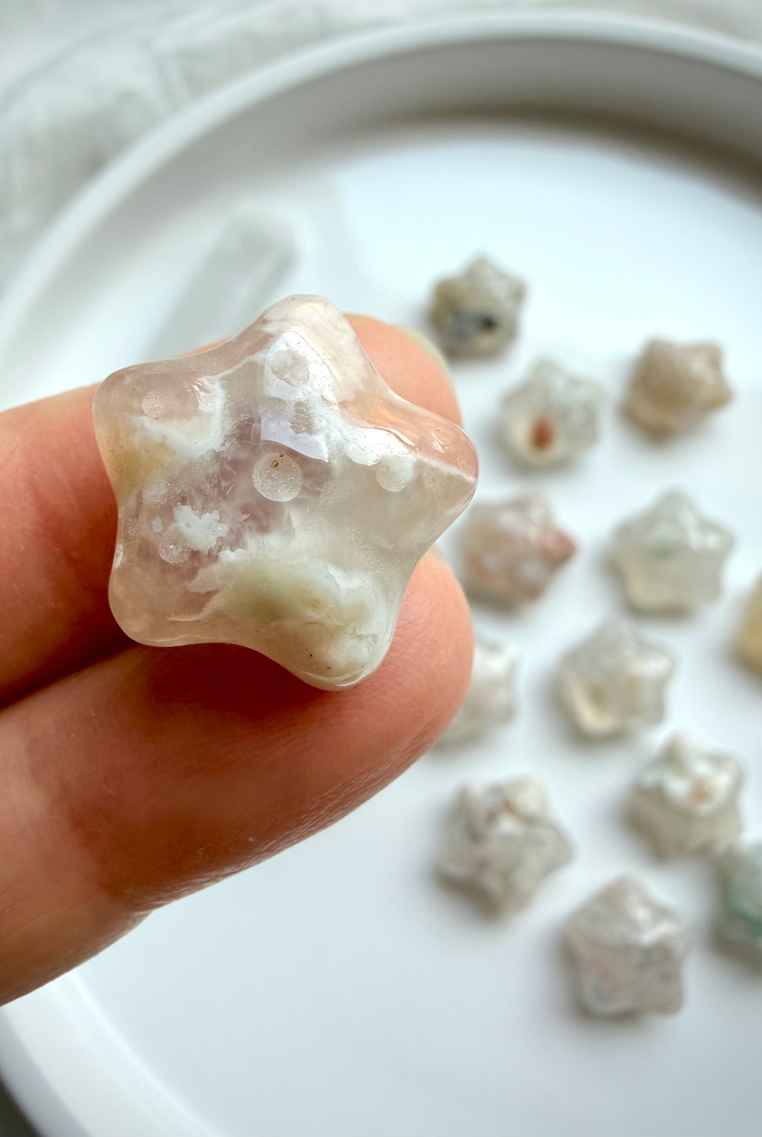 close-up of Flower Agate starfish carvings featuring delicate blossom inclusions and polished crystal surfaces