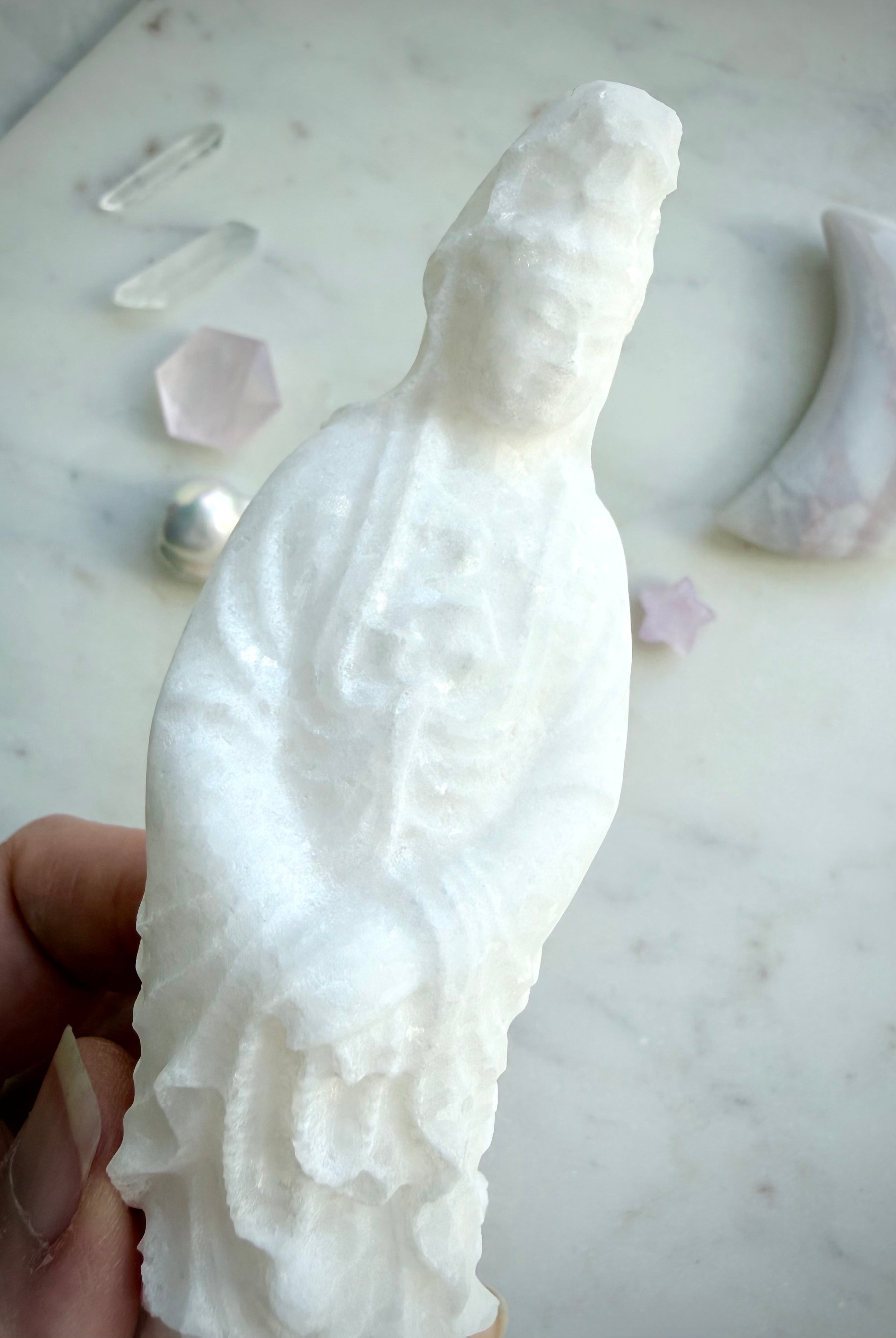 White Jade Quan Yin statue with lotus base displayed in a peaceful meditation setting