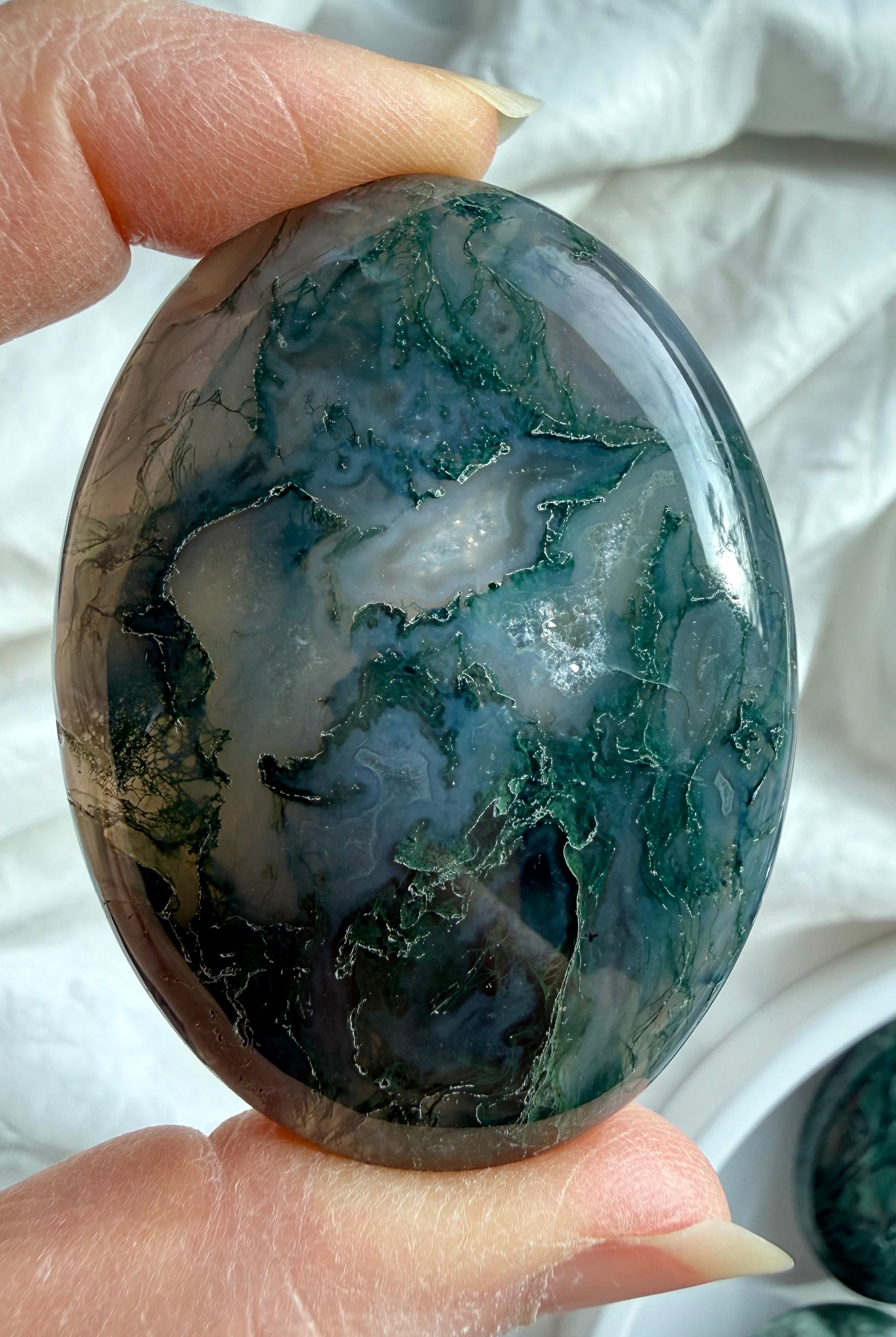 Natural moss agate palm stone with forest-like inclusions and soft green tones, calming crystal for emotional balance