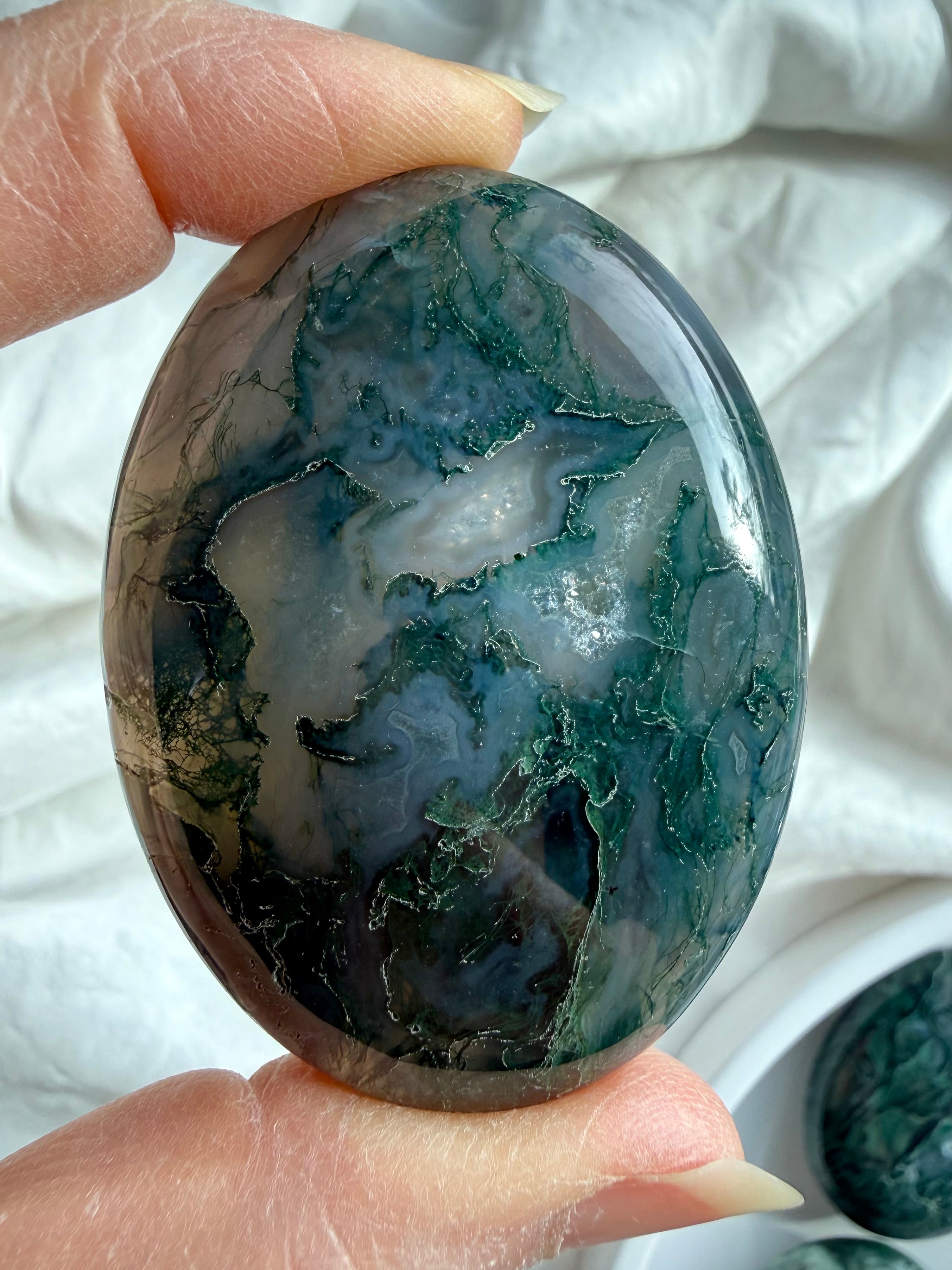 Natural moss agate palm stone with forest-like inclusions and soft green tones, calming crystal for emotional balance