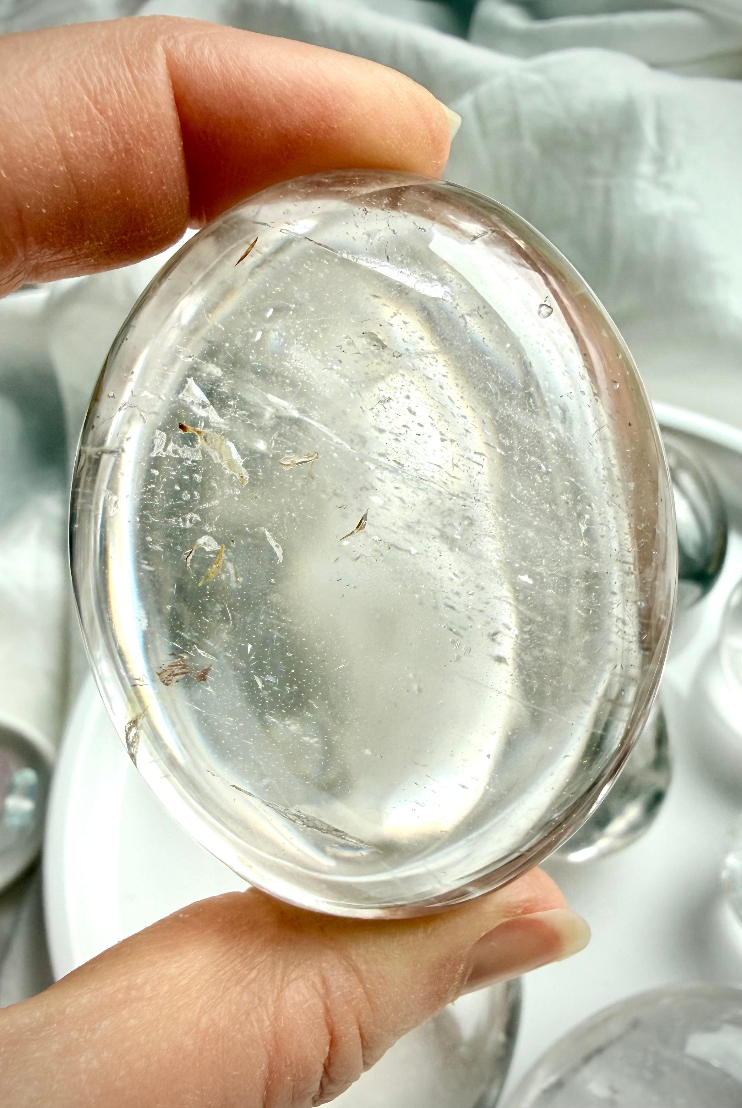close up of a polished clear quartz crystal detail showing natural inclusions and light reflection