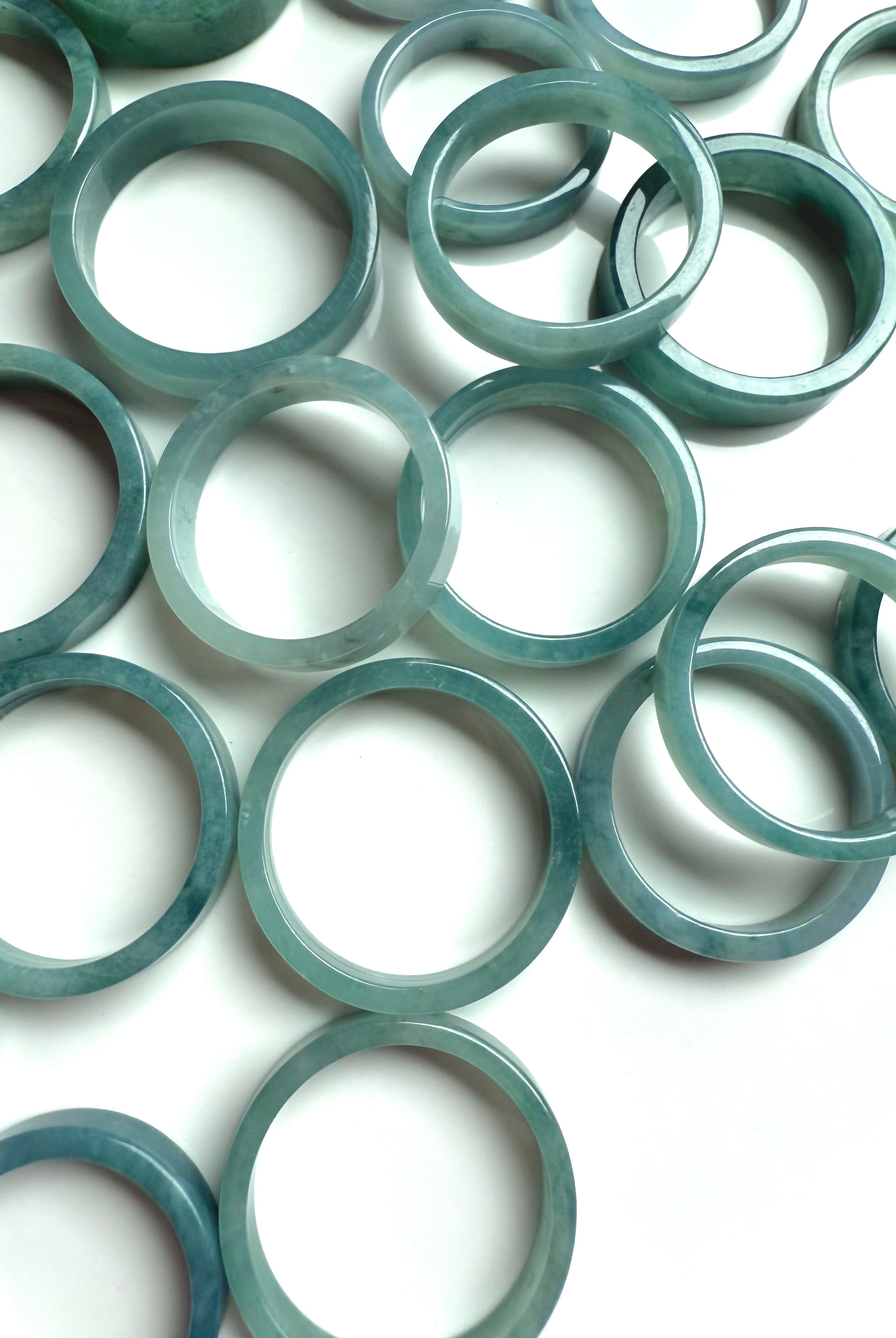 Overhead shot of Blue Water Jade flat rings arranged in a soft scattering for crystal healing display