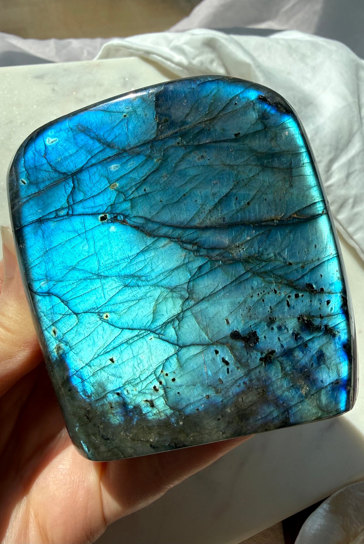 Polished Labradorite freeform with strong electric blue labradorescence shifting across the front