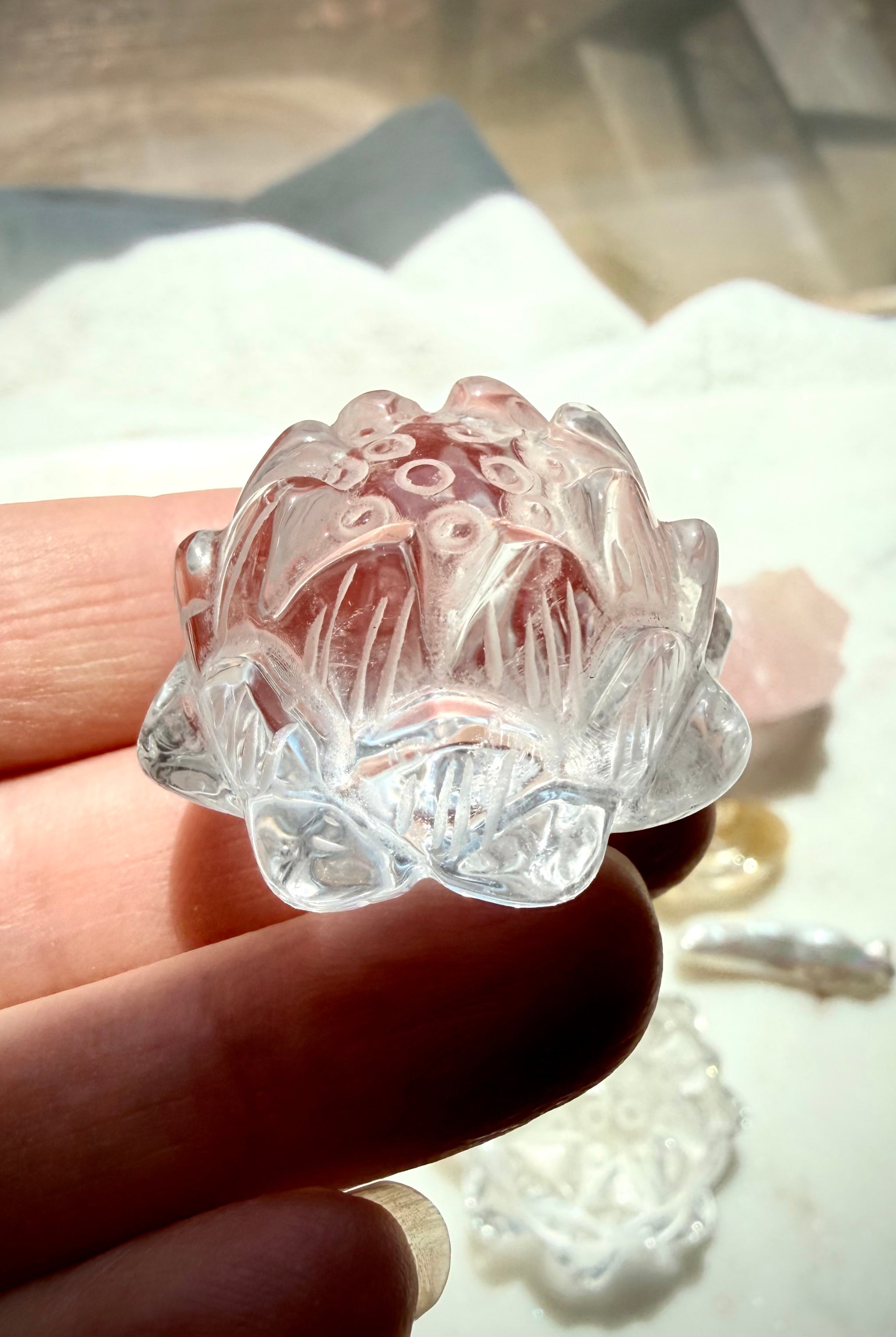 Clear Quartz lotus carving held in hand with luminous polished petals and natural internal veils