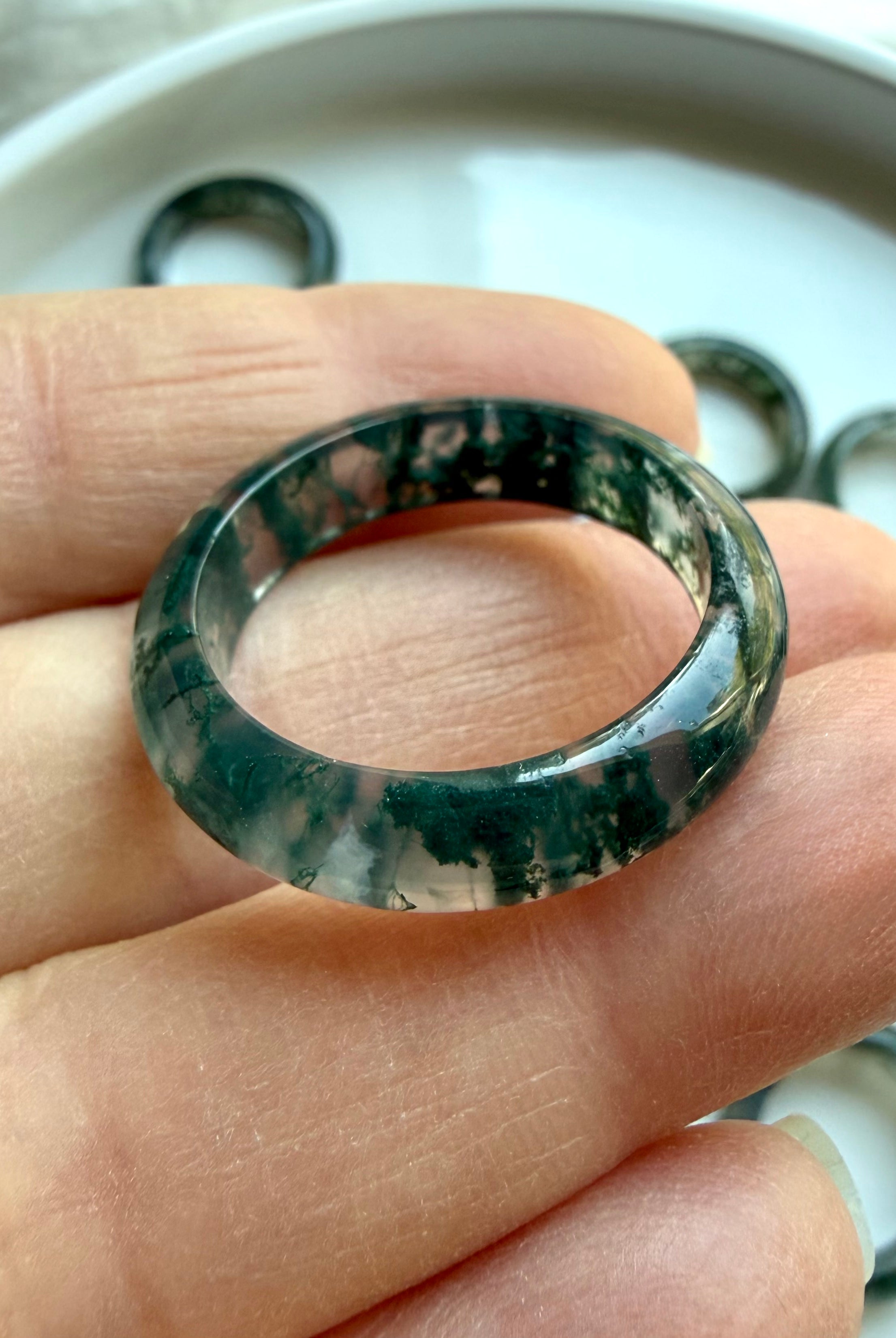 moss agate band ring on hand displaying varied natural patterns, crystal rings for growth stability and nature connection