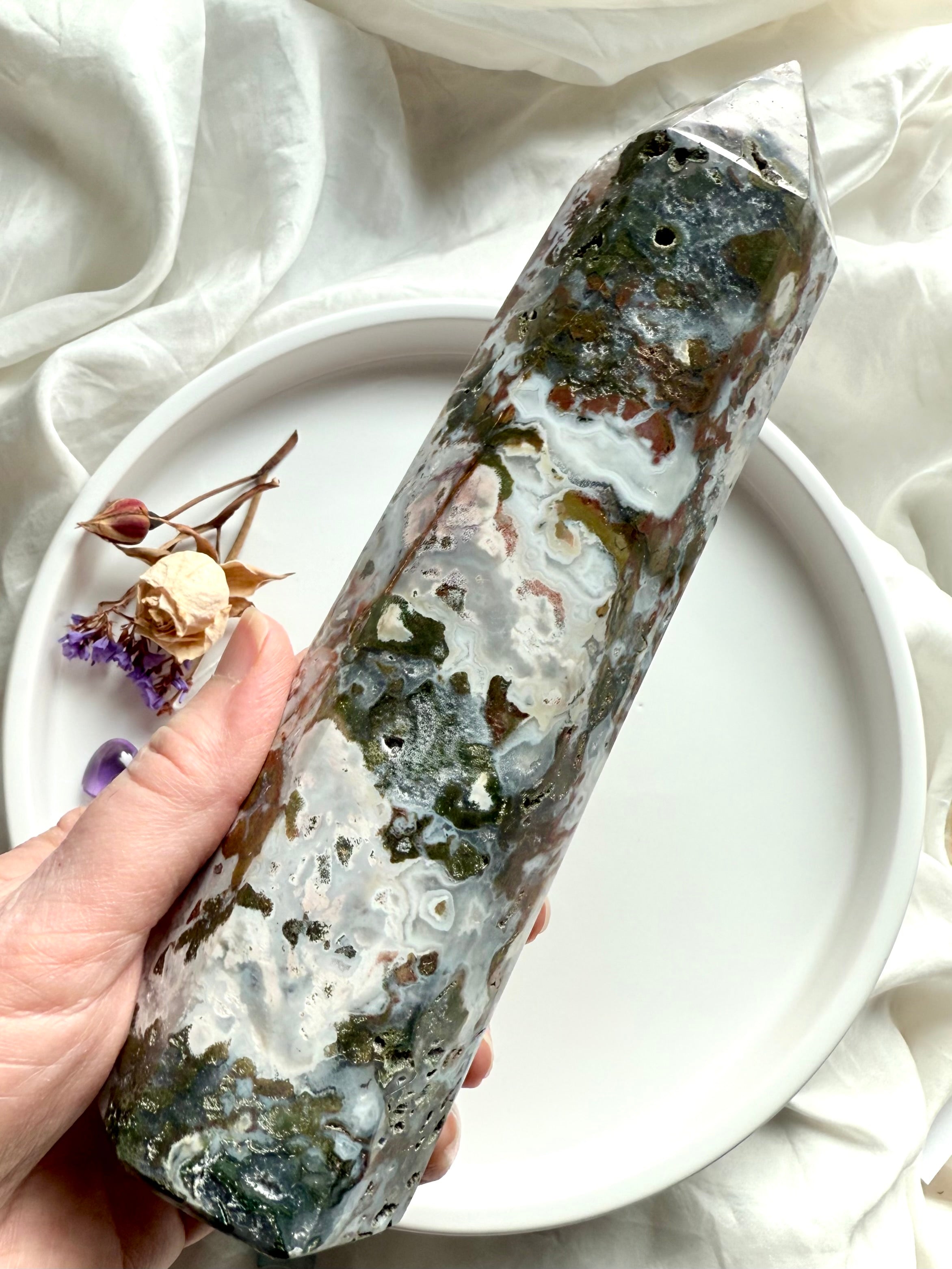 Cosmic Ocean Jasper tower held in hand, showcasing soft blue-gray chalcedony patterns, earthy green inclusions, and natural druzy details