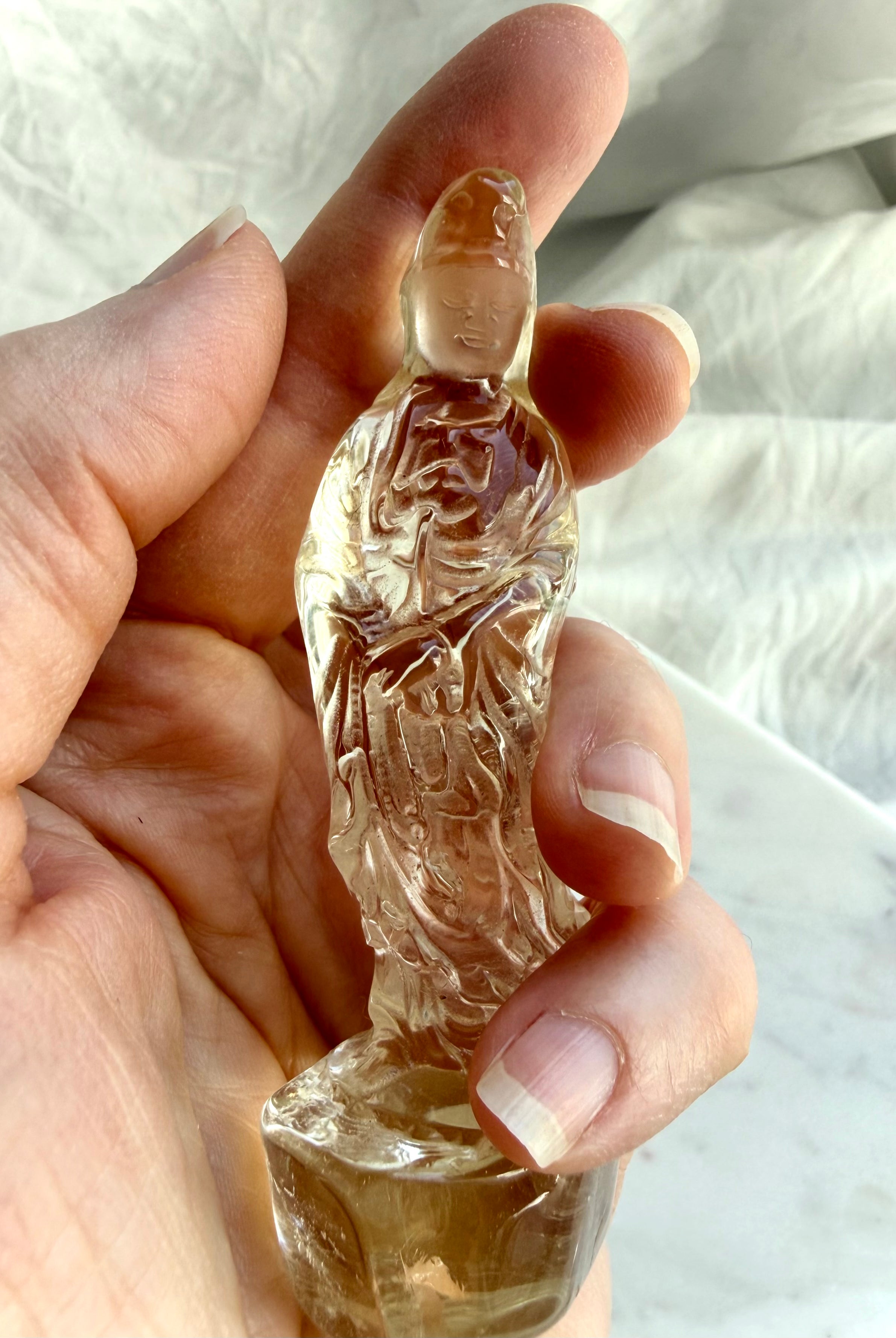 handheld Citrine Quan Yin statue displaying warm golden hues and crystal goddess symbolism