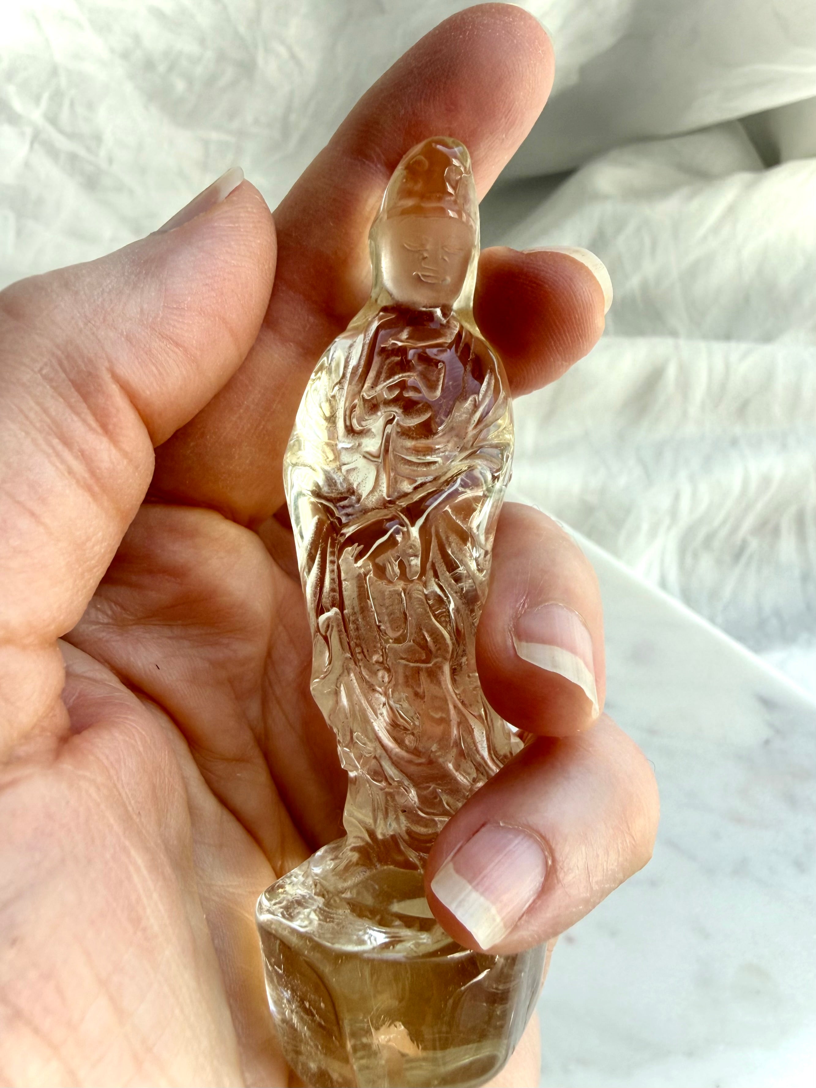 handheld Citrine Quan Yin statue displaying warm golden hues and crystal goddess symbolism