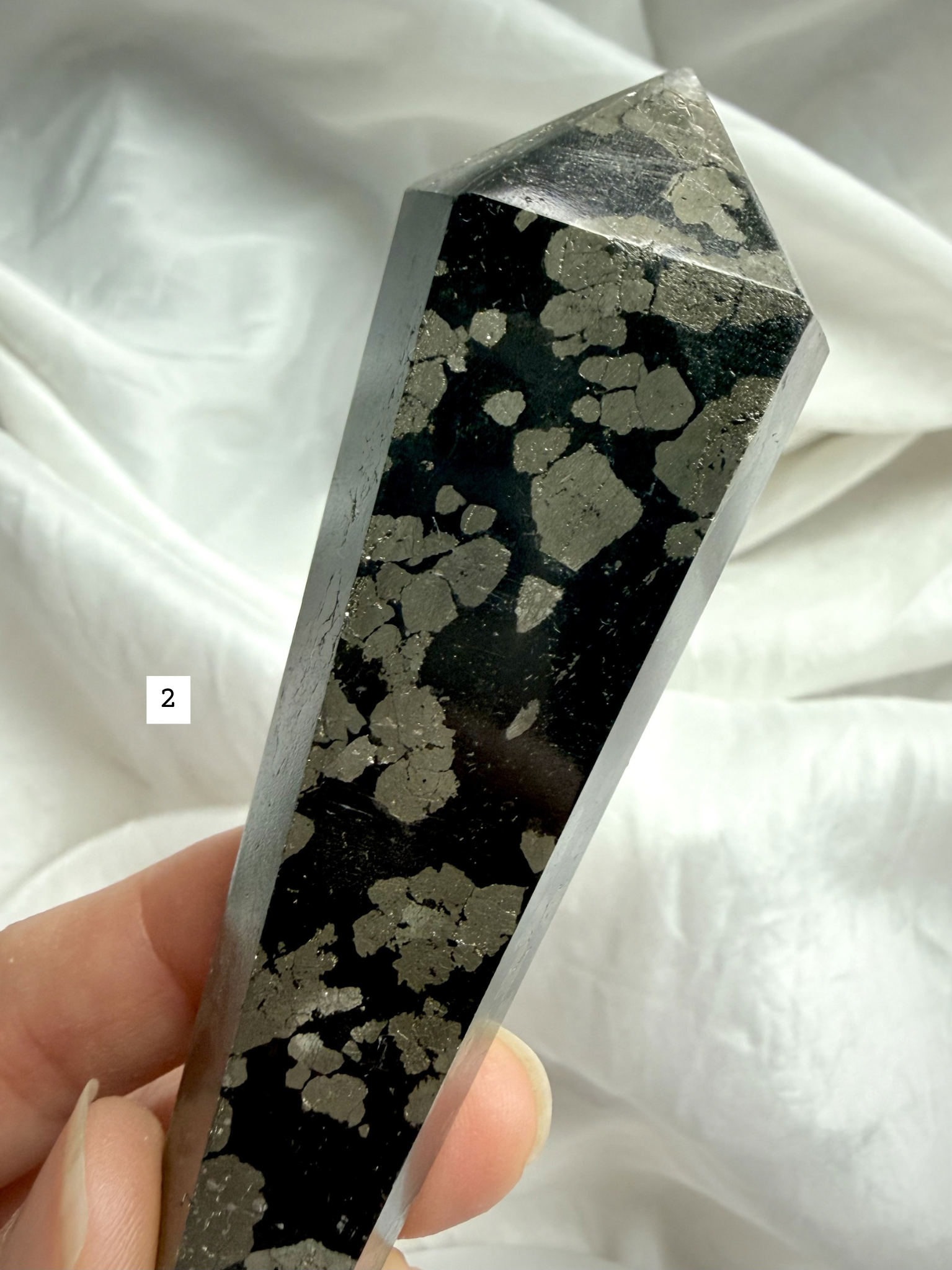 pyrite in black matrix crystal point close up showing natural mineral pattern