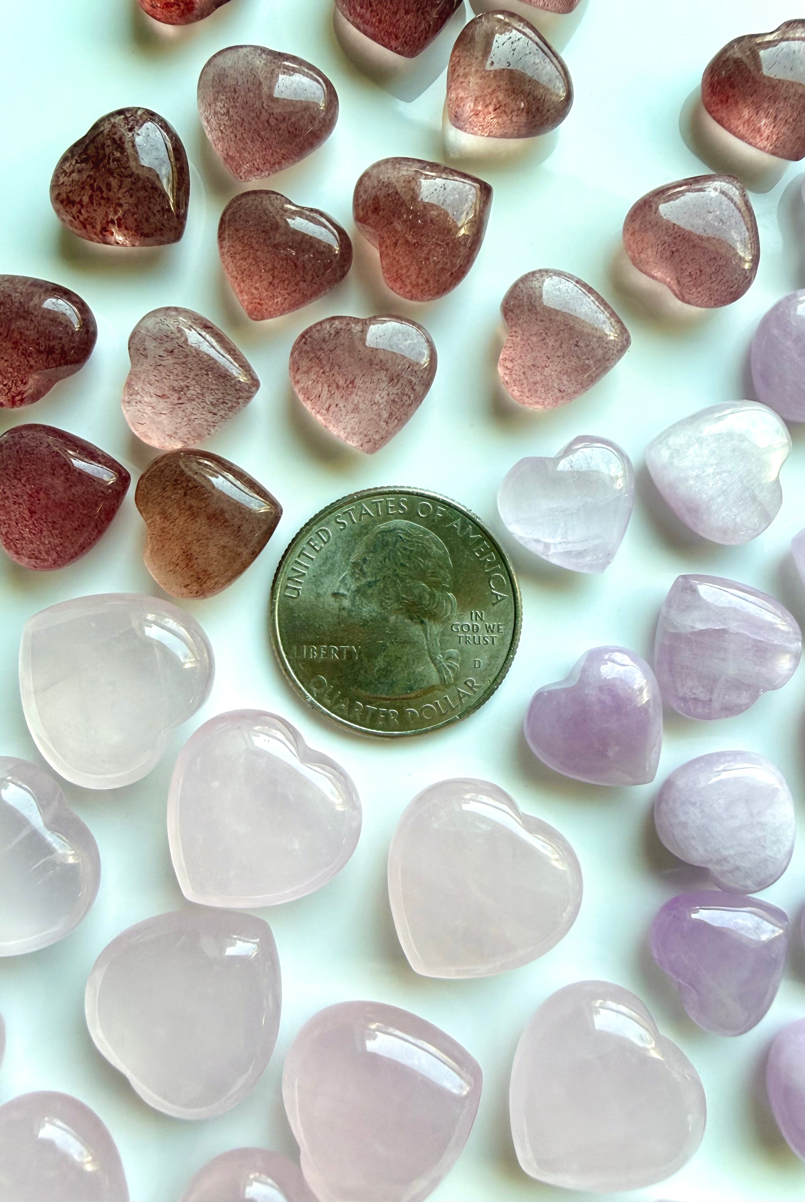 Mini crystal hearts with US quarter for scale showing size of rose quartz, strawberry quartz, and kunzite heart stones