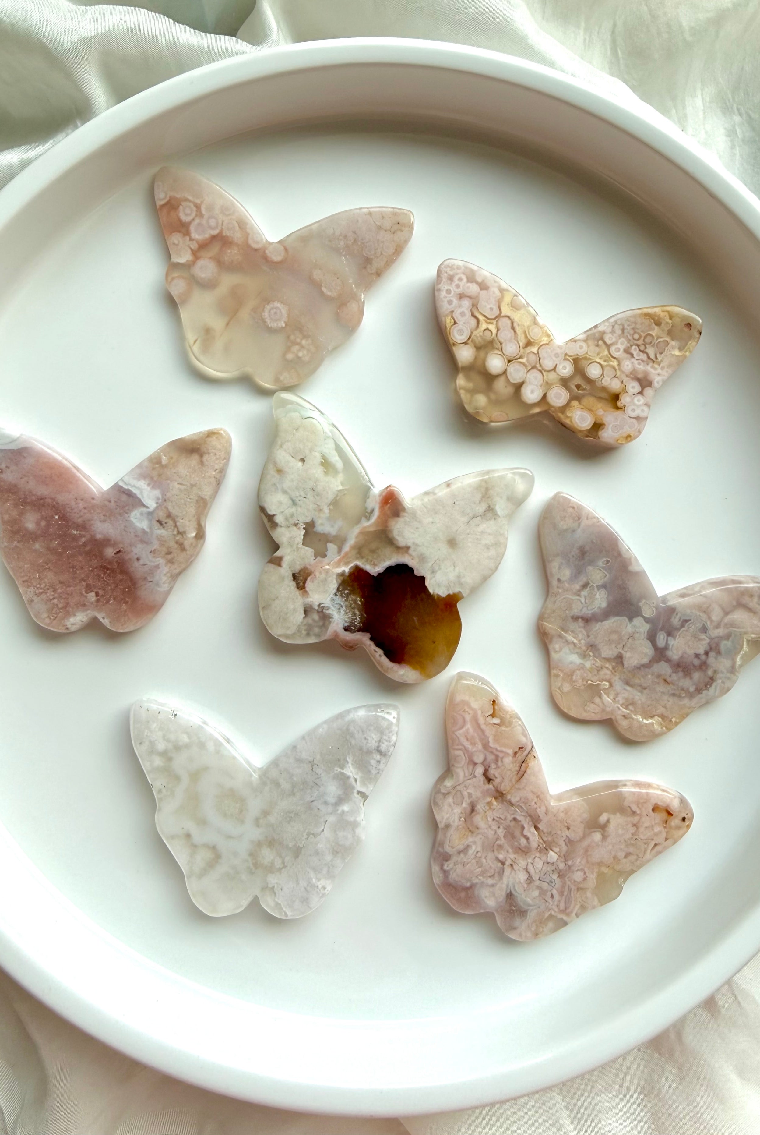 Back view of Flower Agate butterfly crystal carvings showing natural blossom patterns and agate banding