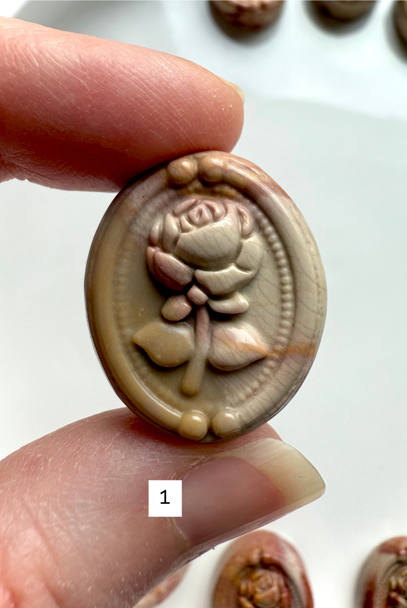 Polychrome Jasper Rose cabochon #1 held in hand showing neutral cream and tan swirls