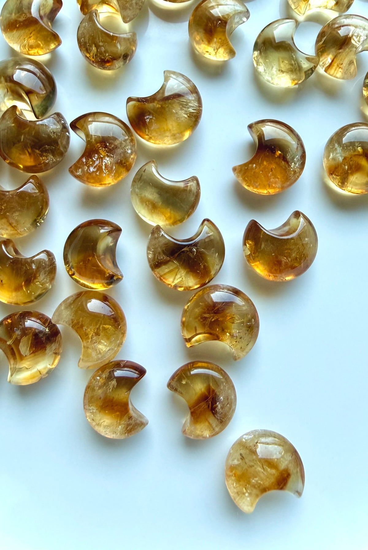 High-clarity Mini Citrine moons with warm amber, honey-gold and champagne tones on a white background