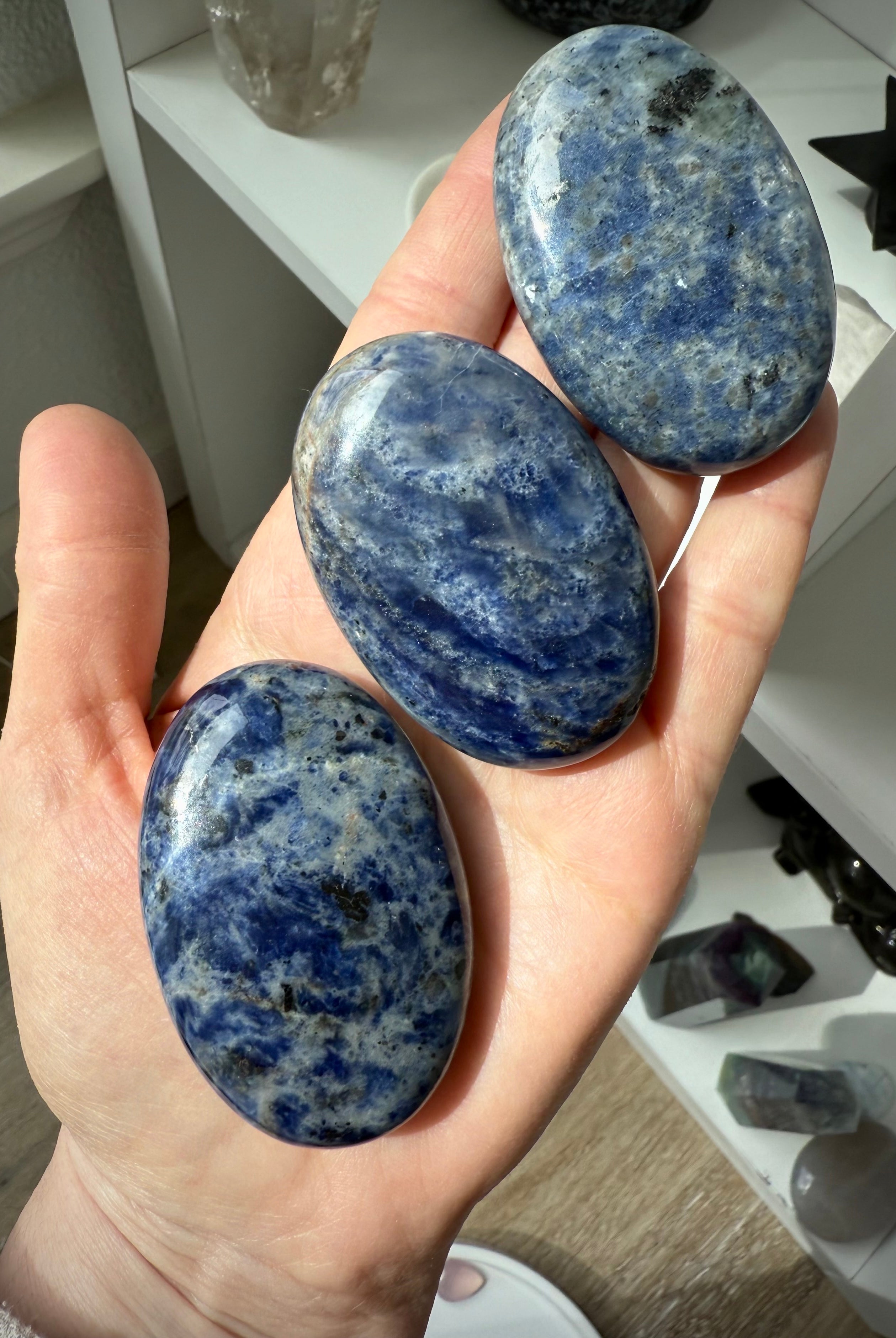 High quality blue Sodalite Palmstones shown on my hand for scale, photographed in natural light