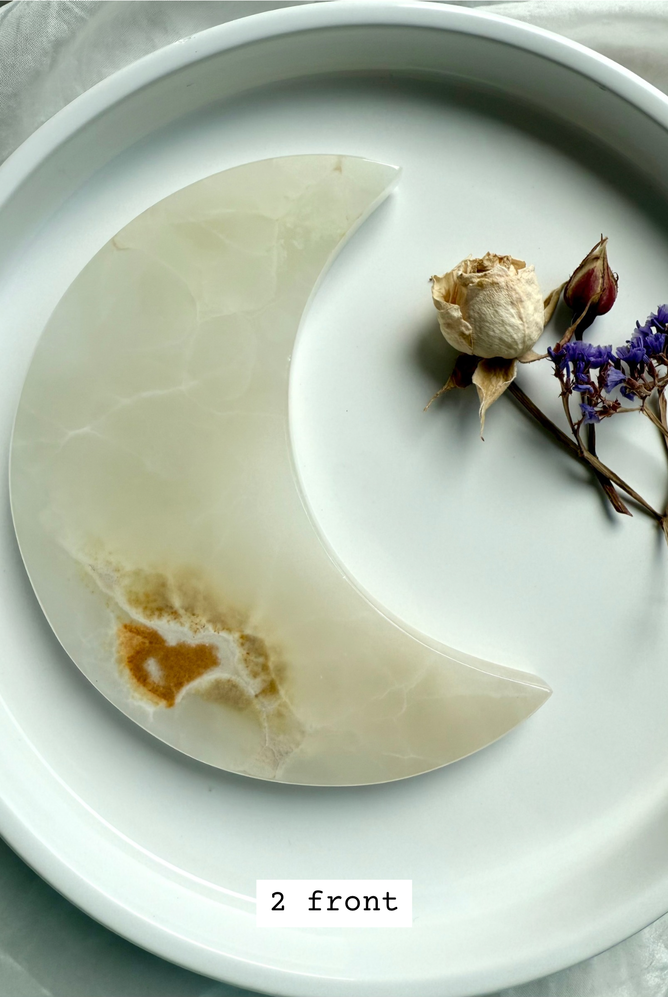 White Onyx Crescent Moon Plate, translucent ivory with golden honey inclusions, front view.