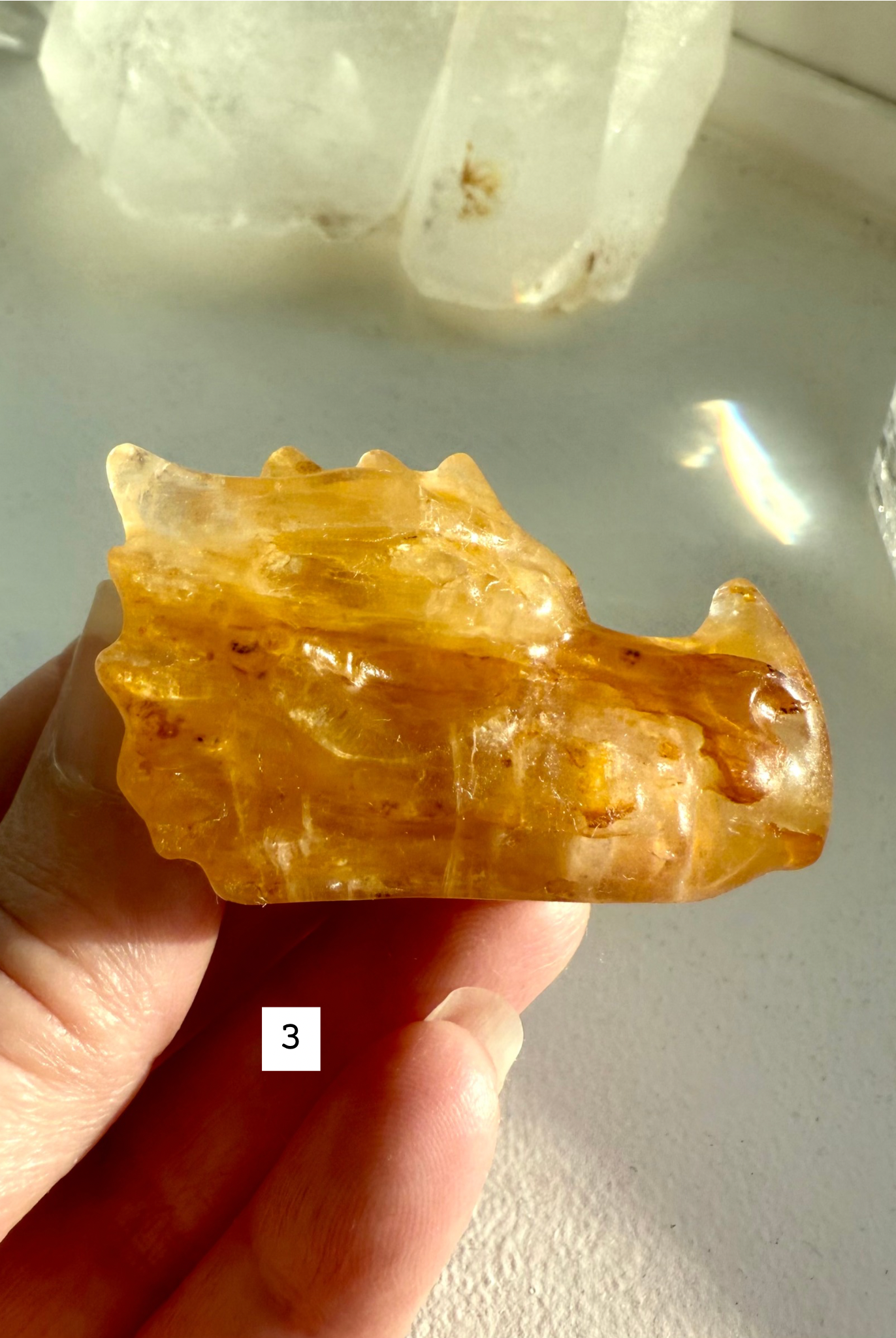 Small Golden Healer Quartz dragon head held in hand — crystal guardian carving for Solar Plexus healing, clarity, and spiritual connection.