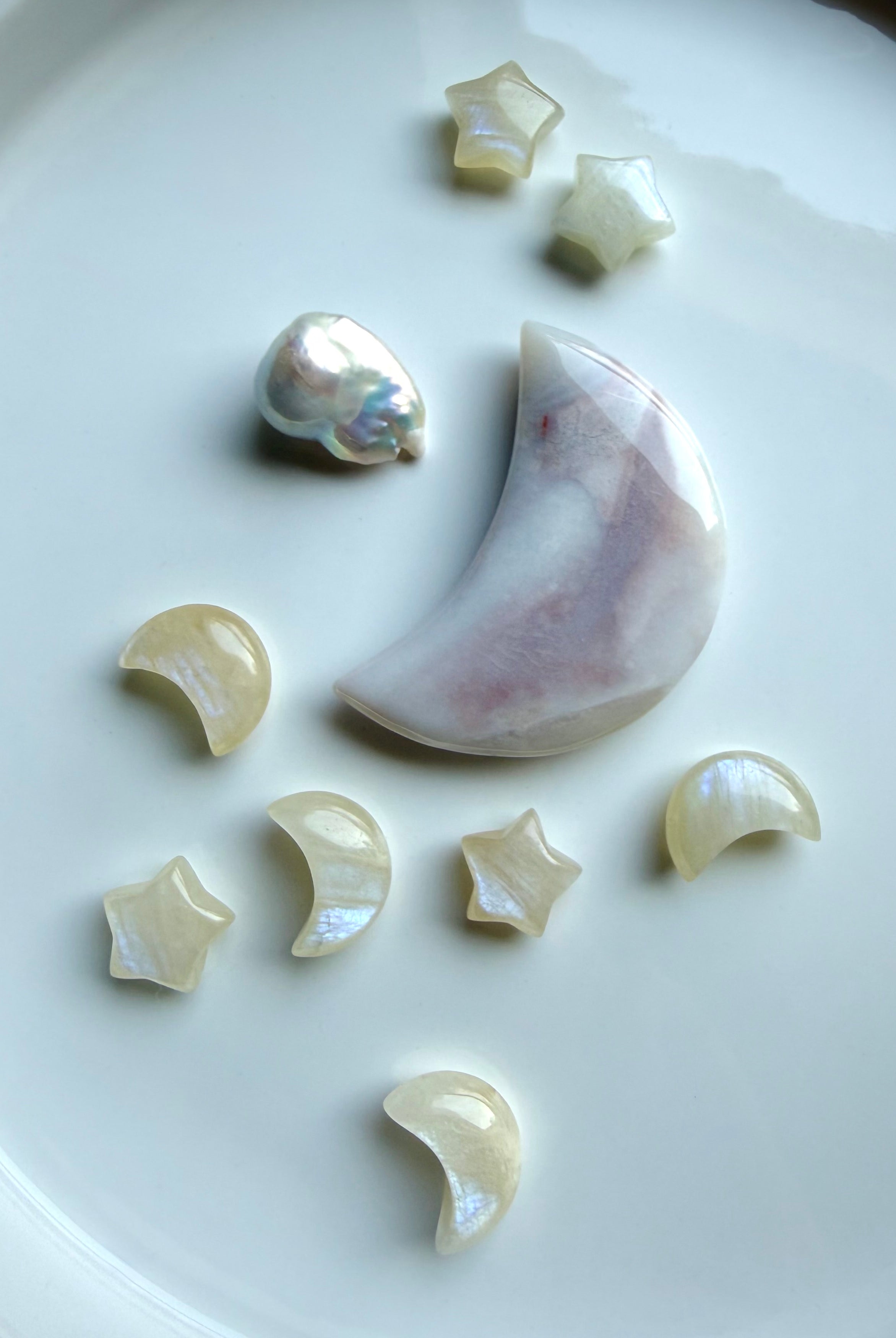 Mini Moonstone moons and stars displayed with an agate moon and baroque pearl on a ceramic tray