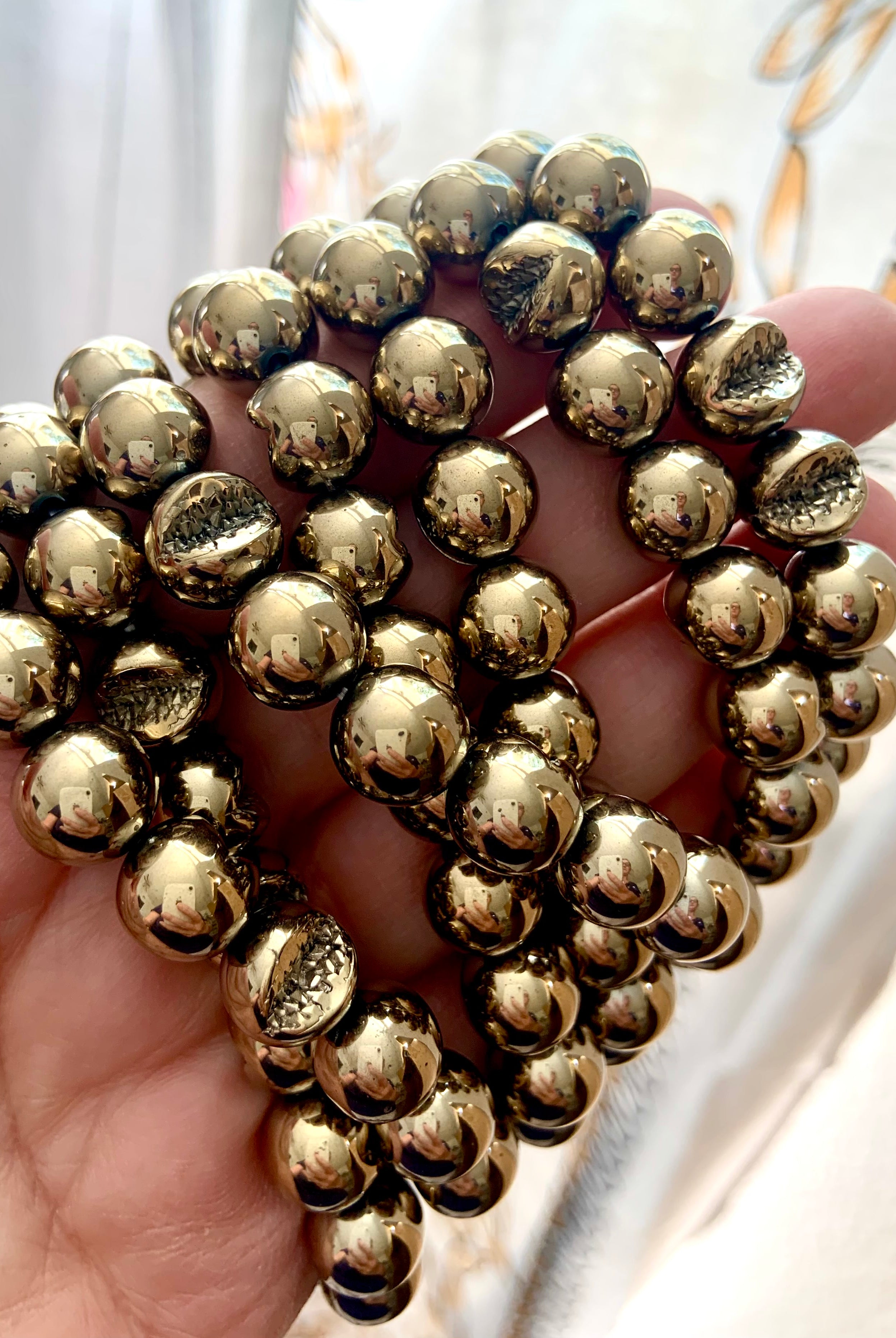 Close-up of round Pyrite beads featuring natural geode pattern — stone of abundance, willpower & energetic shielding.