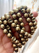 Close-up of round Pyrite beads featuring natural geode pattern — stone of abundance, willpower & energetic shielding.