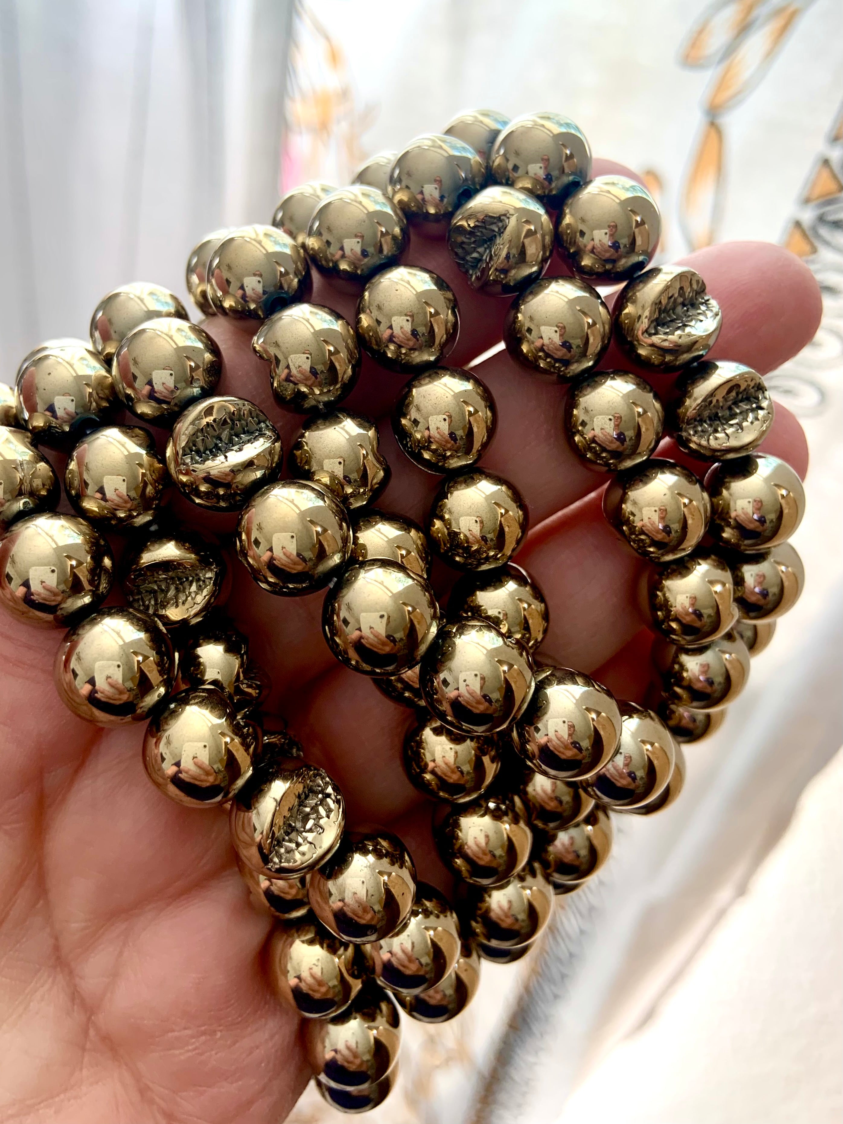 Close-up of round Pyrite beads featuring natural geode pattern — stone of abundance, willpower & energetic shielding.