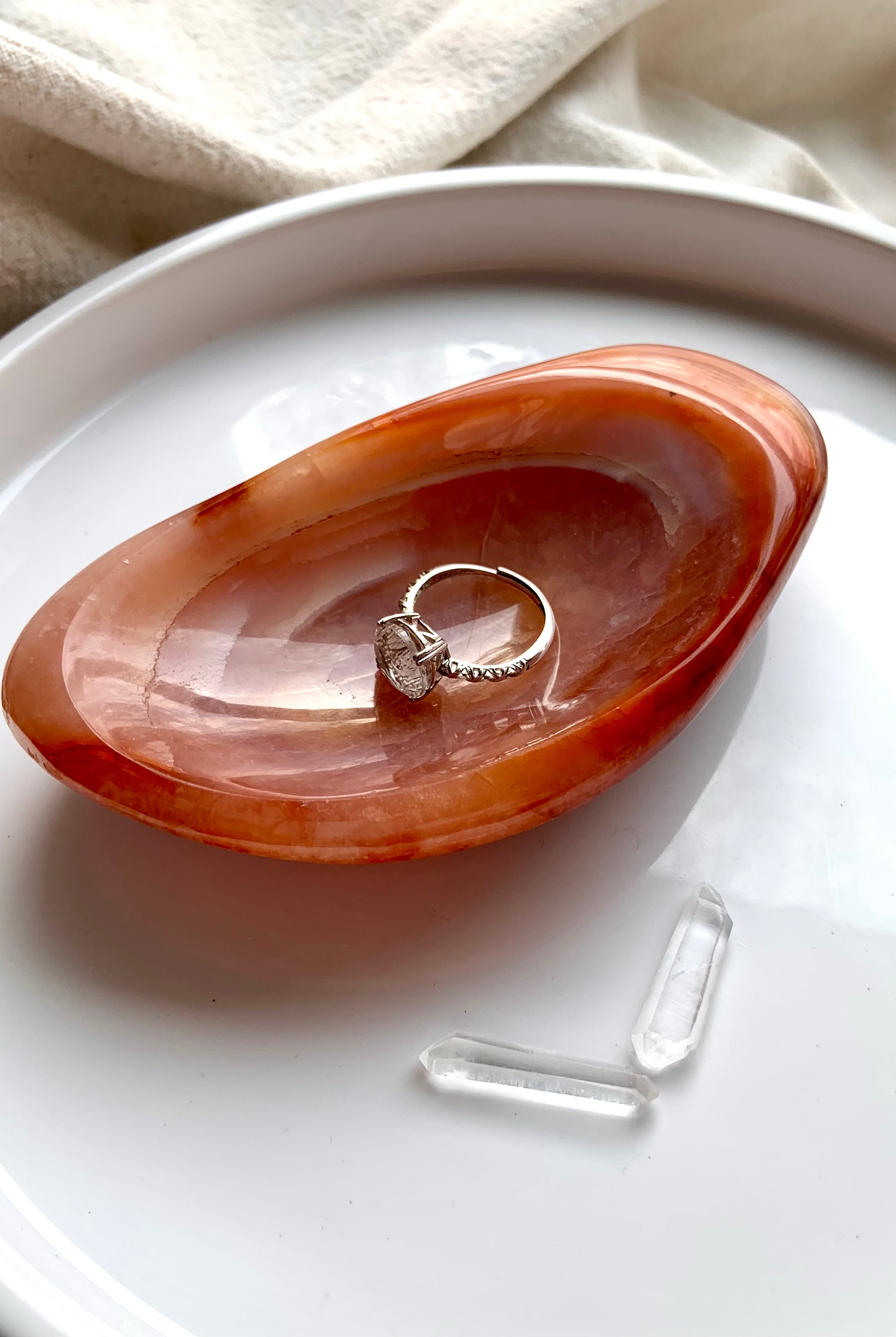 dainty moon ring displayed in orange carnelian crystal bowl with clear quartz points