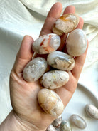 High quality Flower Agate tumbled stones with pastel color patterns shown on a hand for scale