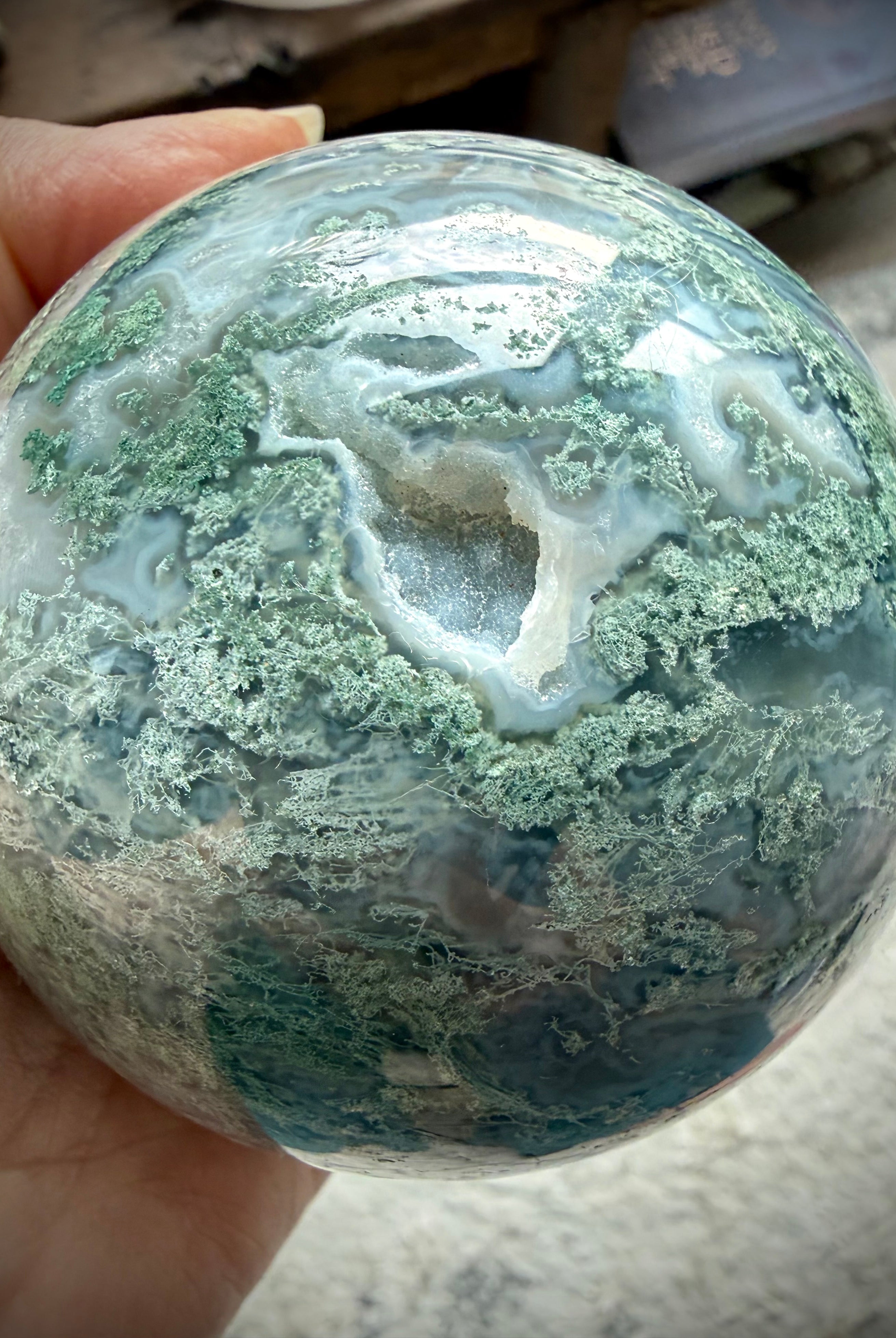 Druzy Moss Agate crystal ball close up with sparkling cave, Quartz pocket, and intricate moss-like inclusions