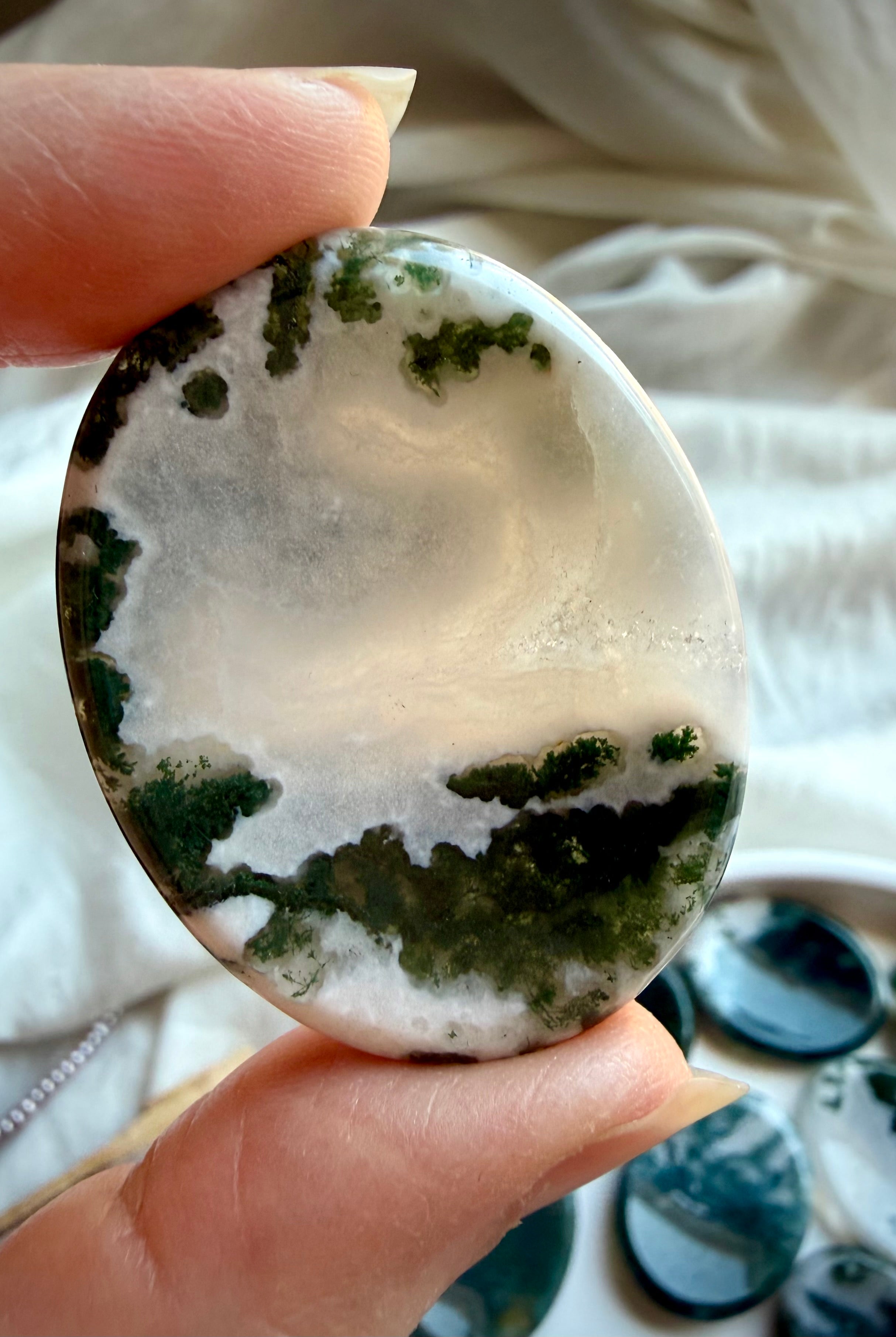 Polished Moss Agate oval thumb stones showing natural variation in green inclusions and clear quartz