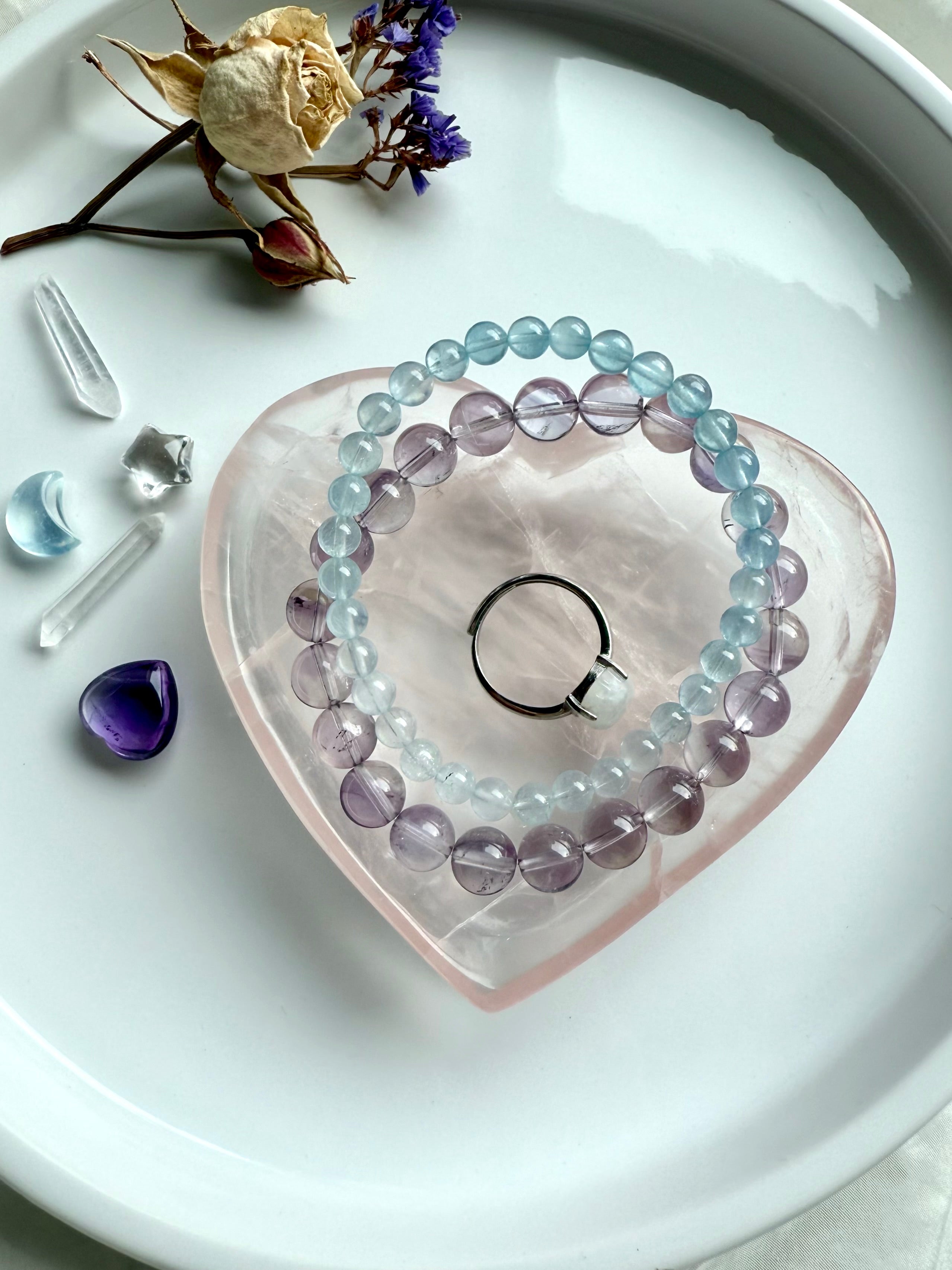 Rose Quartz heart bowl styled as a jewelry display dish on a vanity, holding crystal bracelets and a ring for a soft, feminine metaphysical décor look.