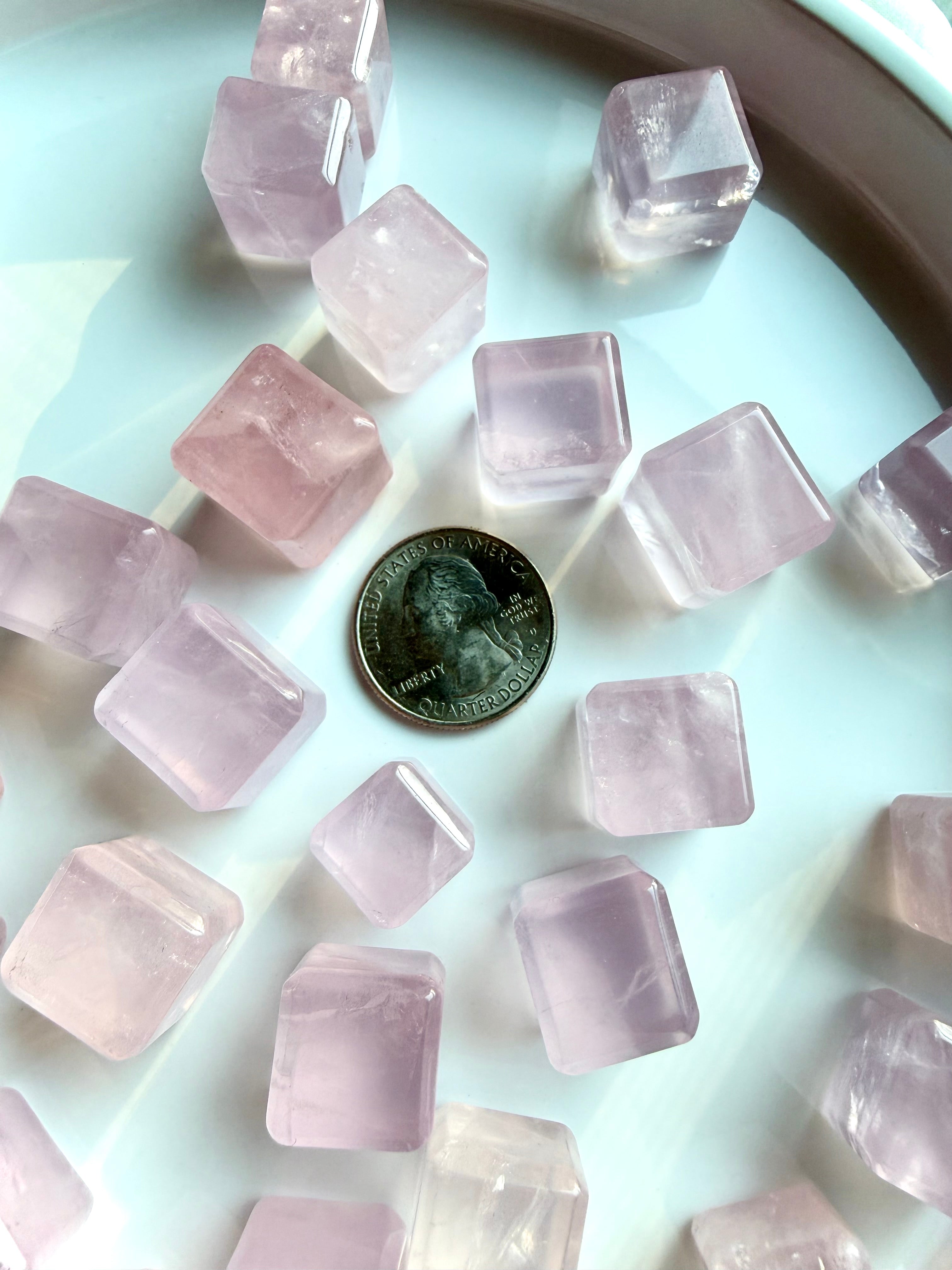 Mini rose quartz cube crystal shown next to a quarter for size reference, polished sacred geometry heart chakra stone