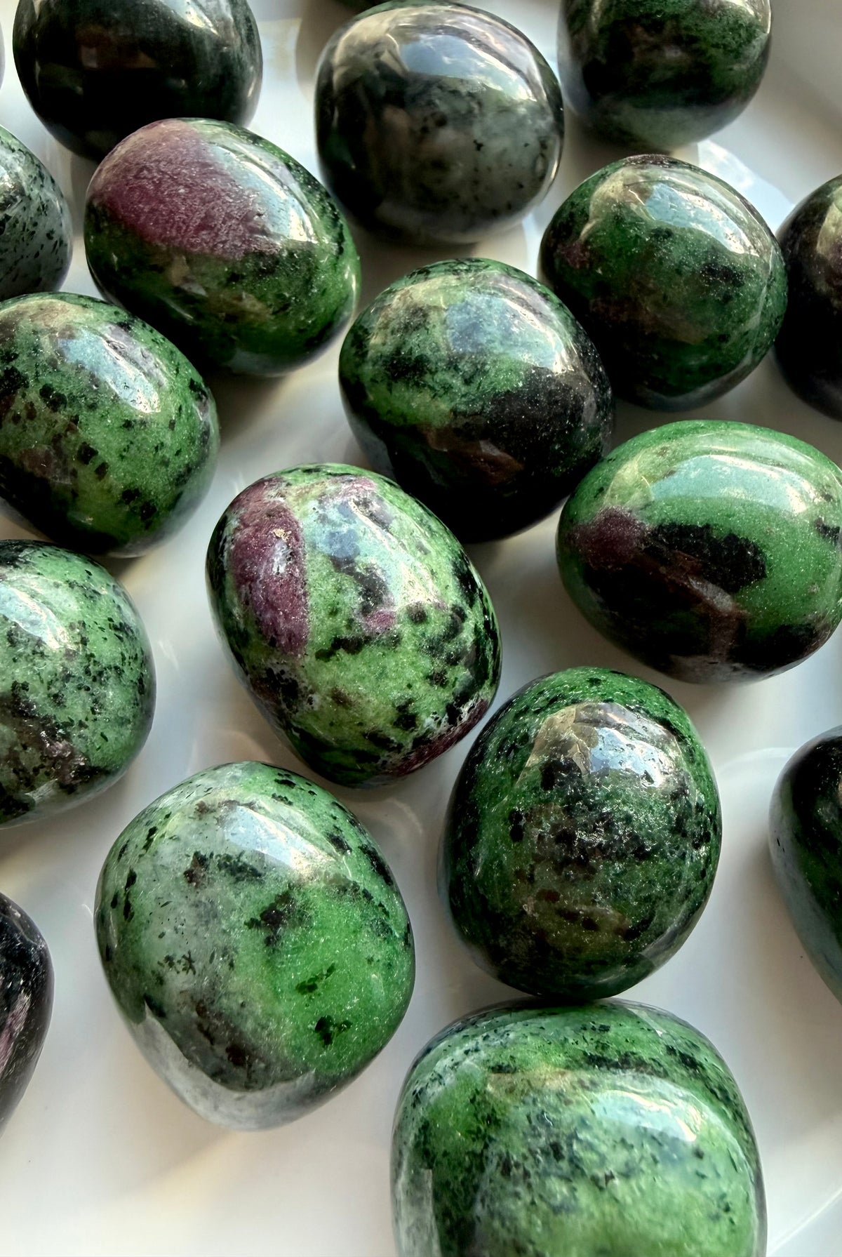 Close-up of Ruby Zoisite tumbled stones revealing natural ruby inclusions, vibrant green Zoisite and unique gemstone patterns