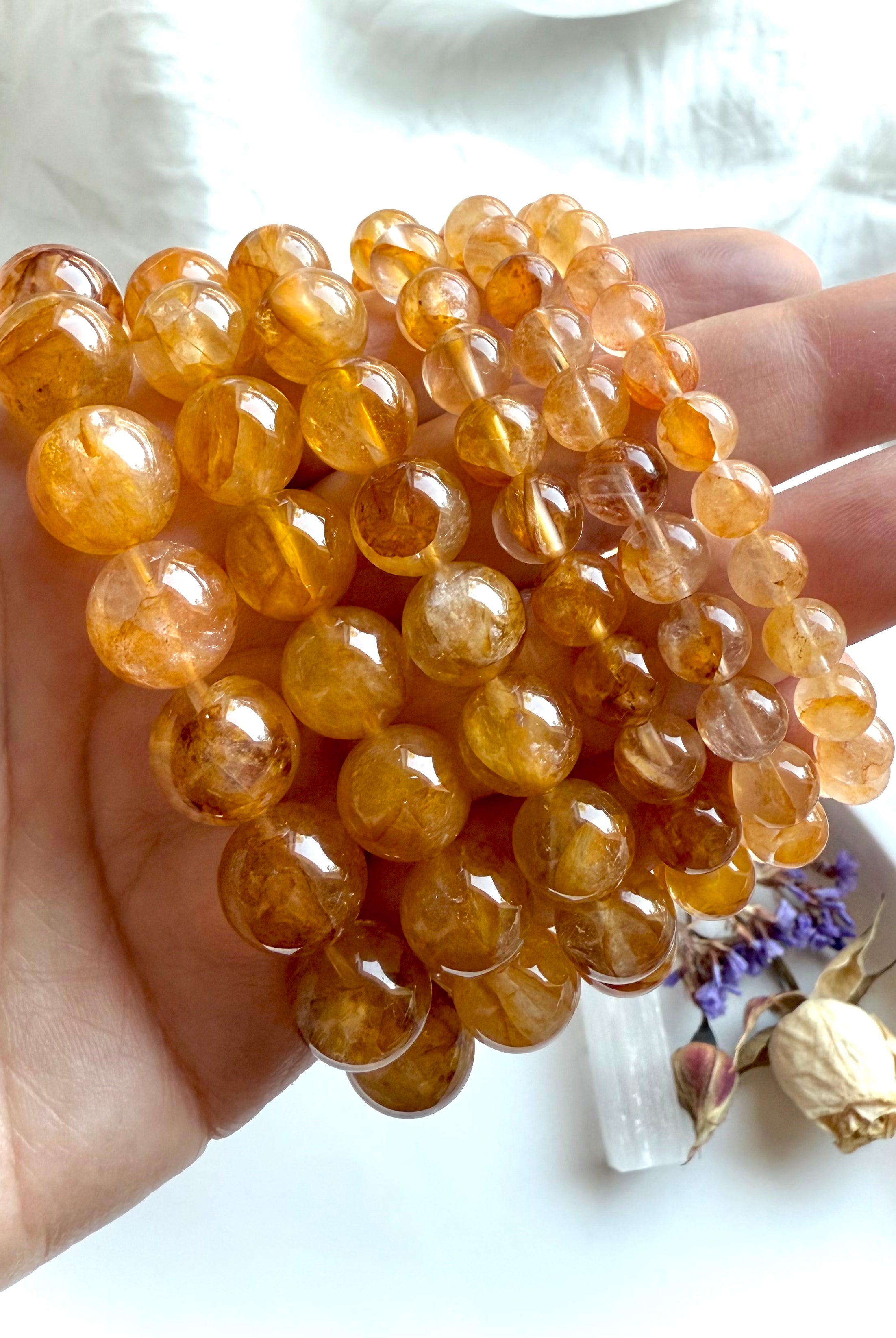 High-quality Golden Healer Quartz beads with rich golden inclusions and clear quartz transparency, gemstone jewelry detail.