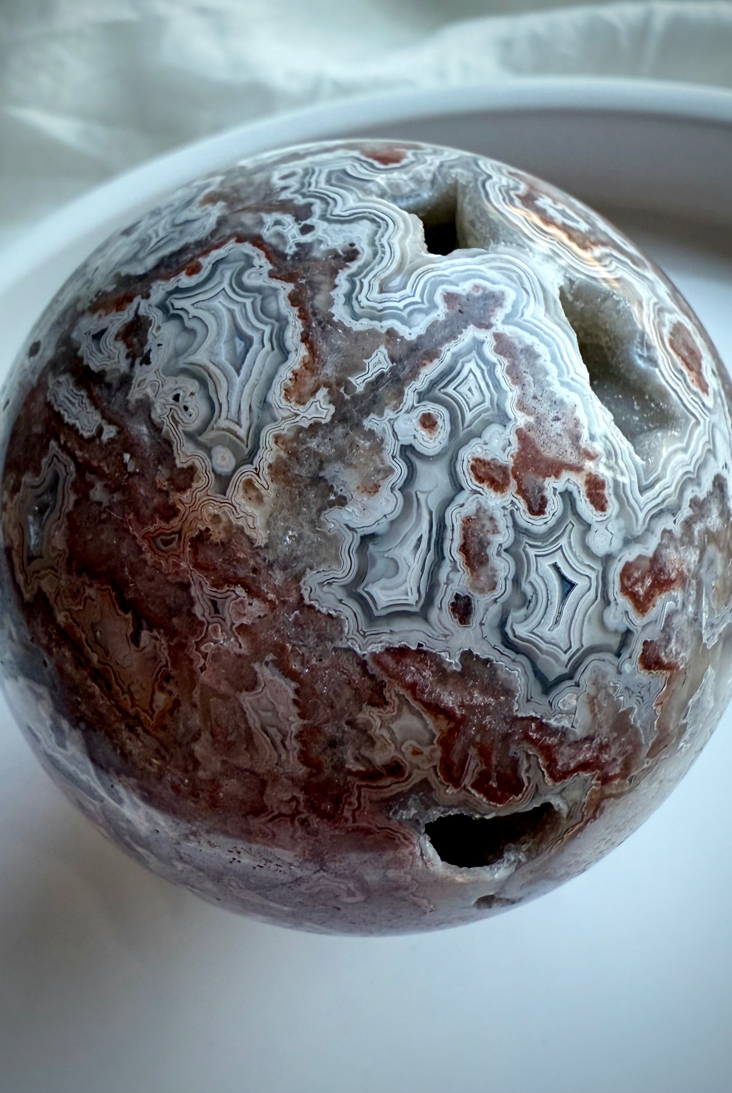 Crazy Lace Agate sphere showing vivid red and cream swirls with grounding crystal energy