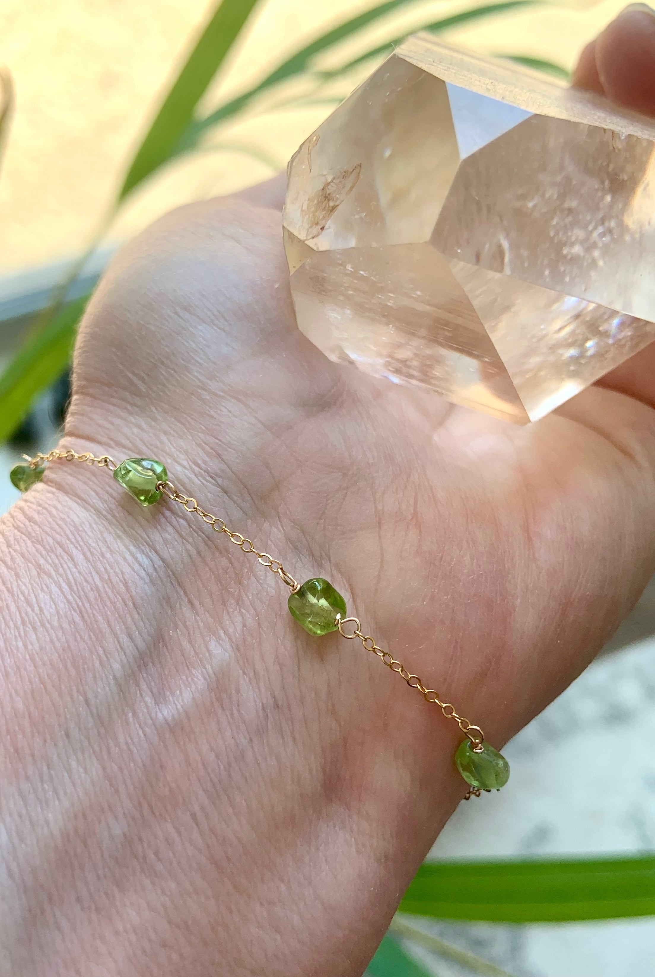 Dainty Peridot gemstone bracelet  shown in gold, on a wrist, also available in sterling silver
