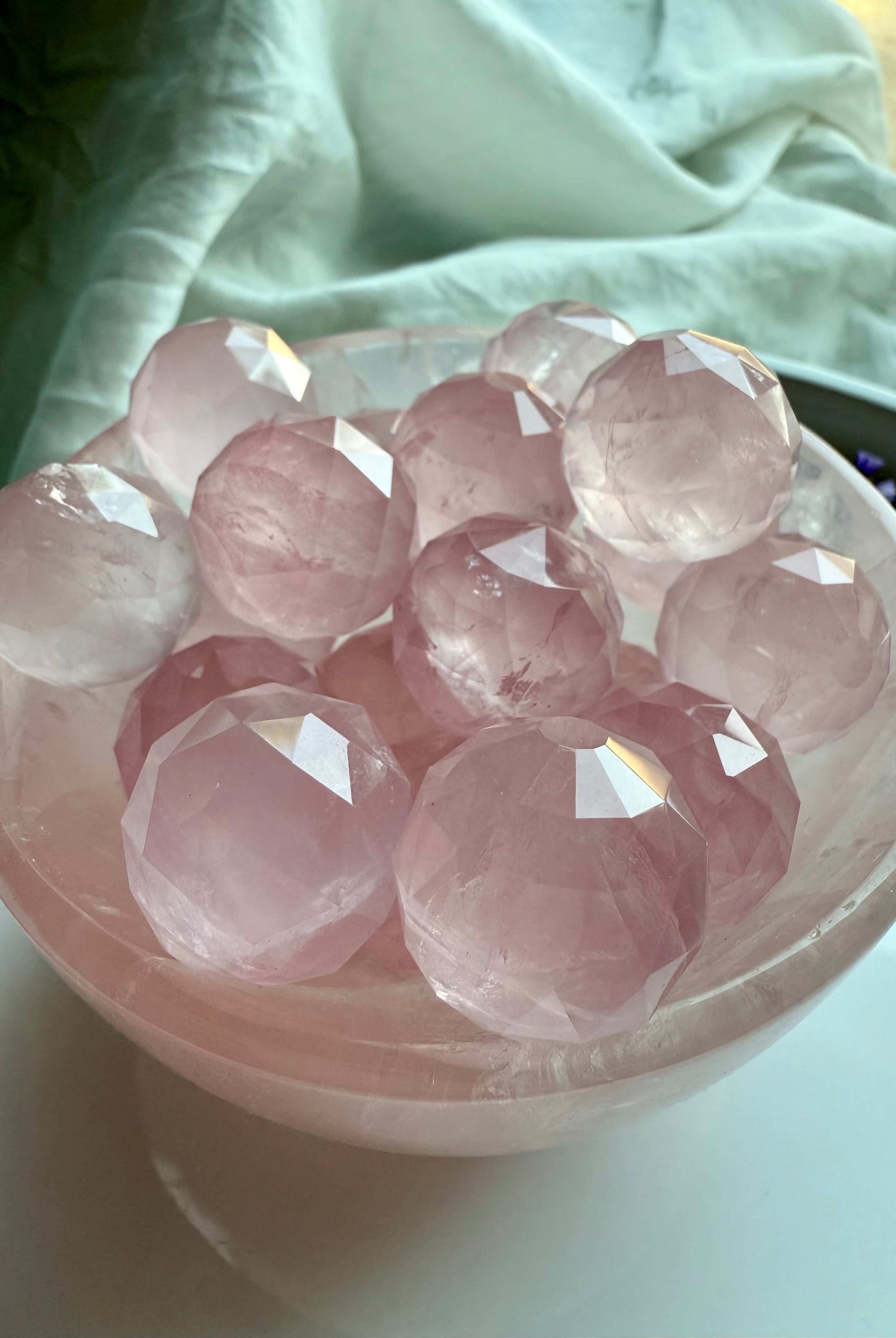 Pink rose quartz crystal balls in a crystal bowl for heart chakra healing