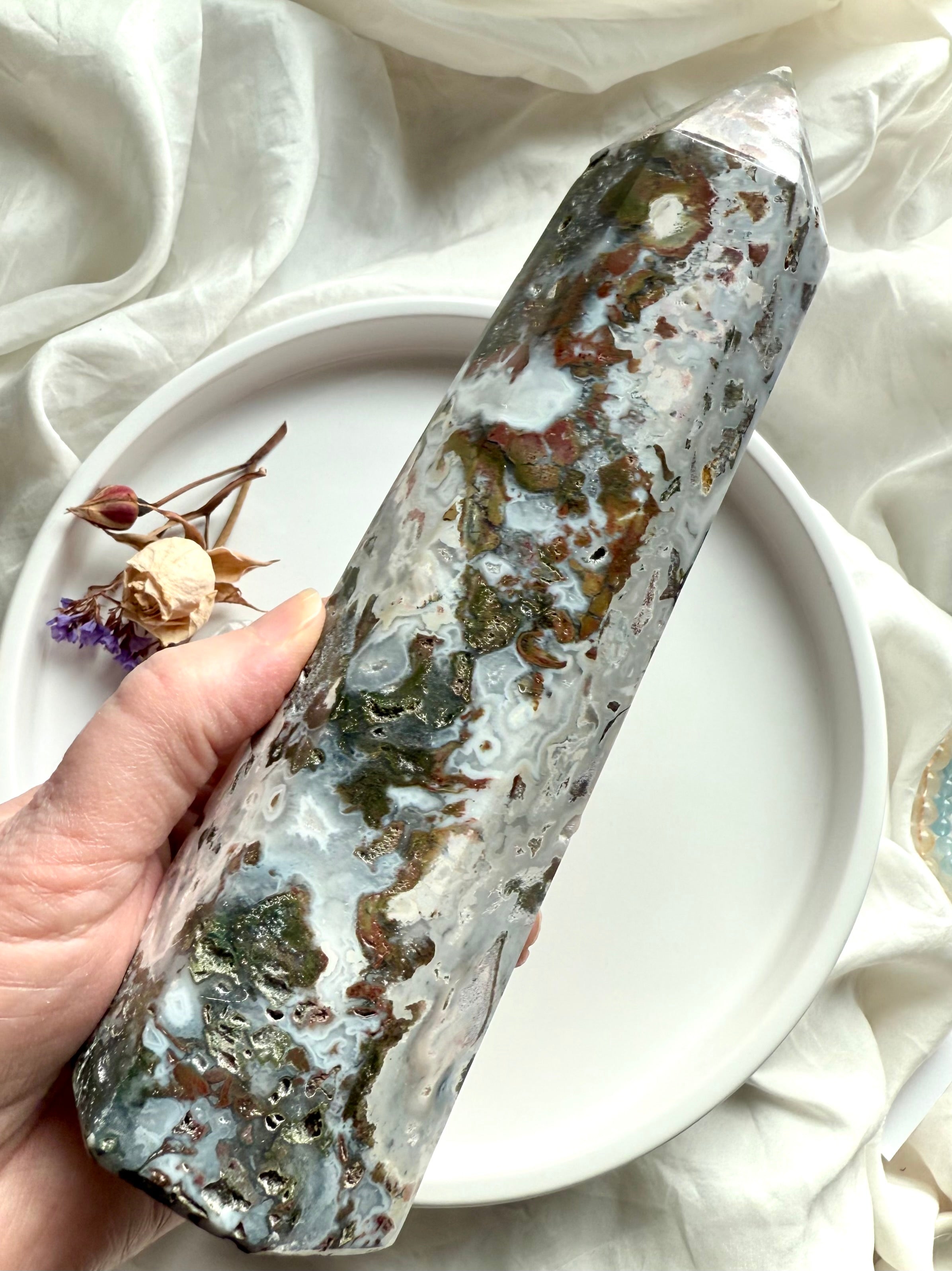 Cosmic Ocean Jasper crystal tower held in hand, highlighting natural patterning, grounding textures, and soothing ocean colors