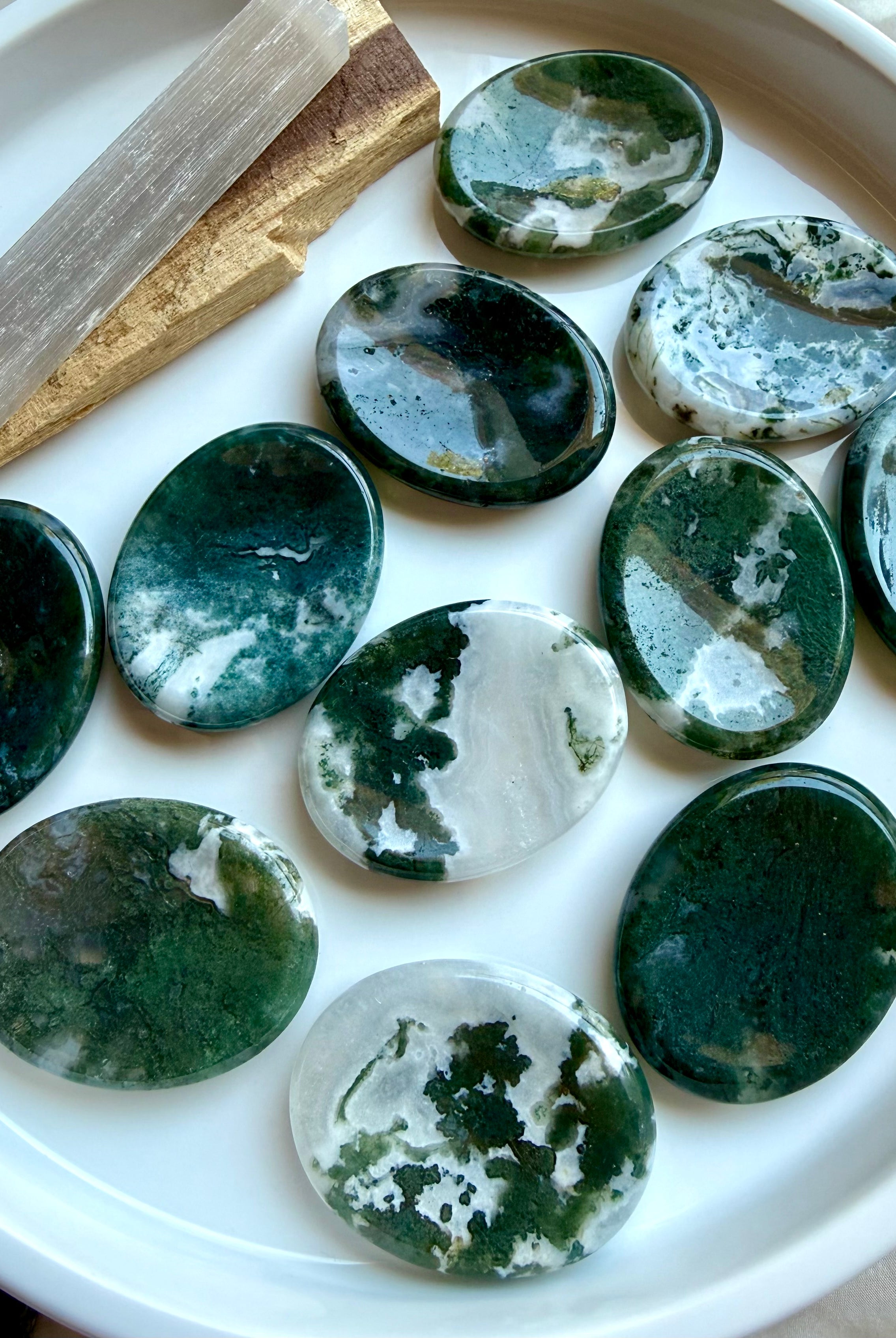 Assorted polished Moss Agate oval worry stones displaying unique green dendritic patterns