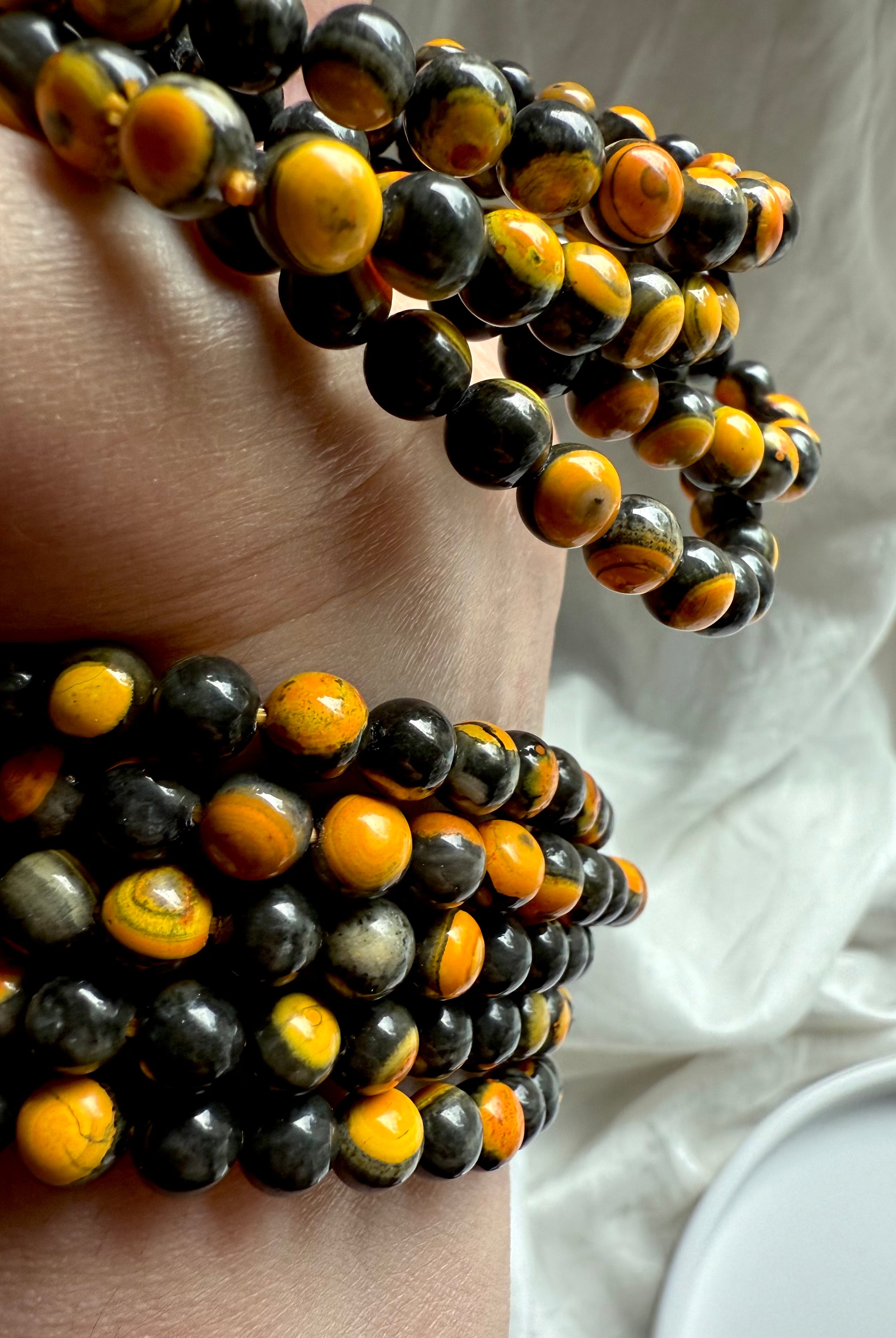 Bumblebee jasper bracelets stacked on wrist, vivid golden yellow with earthy black matrix for grounding and personal empowerment