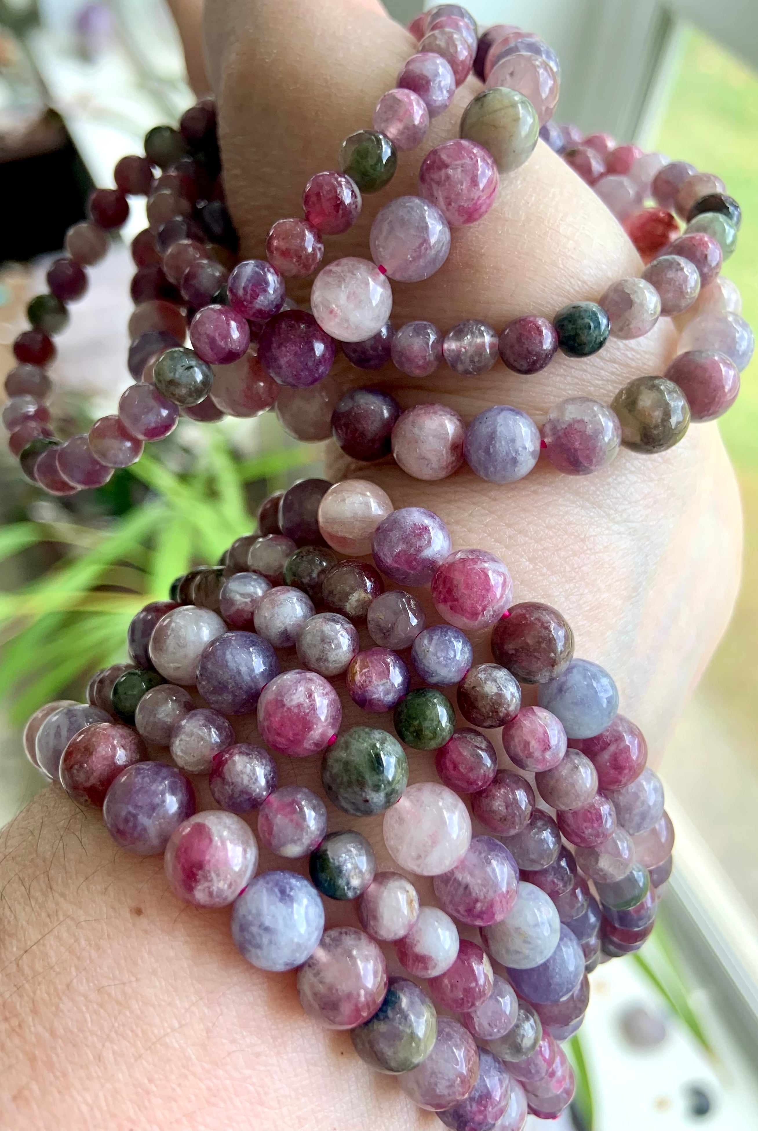 Green Unicorn Stone aka Watermelon Tourmaline & Lepidolite bracelets stacked on wrist and hand — heart chakra crystal bracelets in mixed bead sizes for emotional balance + calm