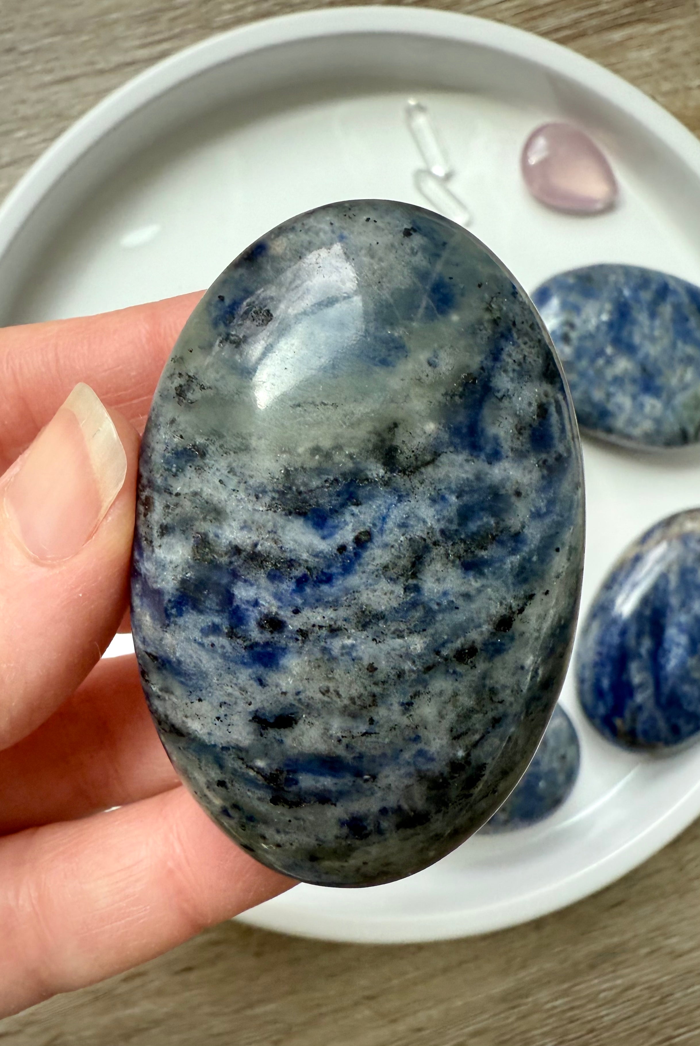 Close up picture of a high quality blue Sodalite Palm Stone held in my hand for scale