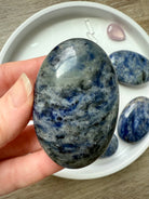 Close up picture of a high quality blue Sodalite Palm Stone held in my hand for scale