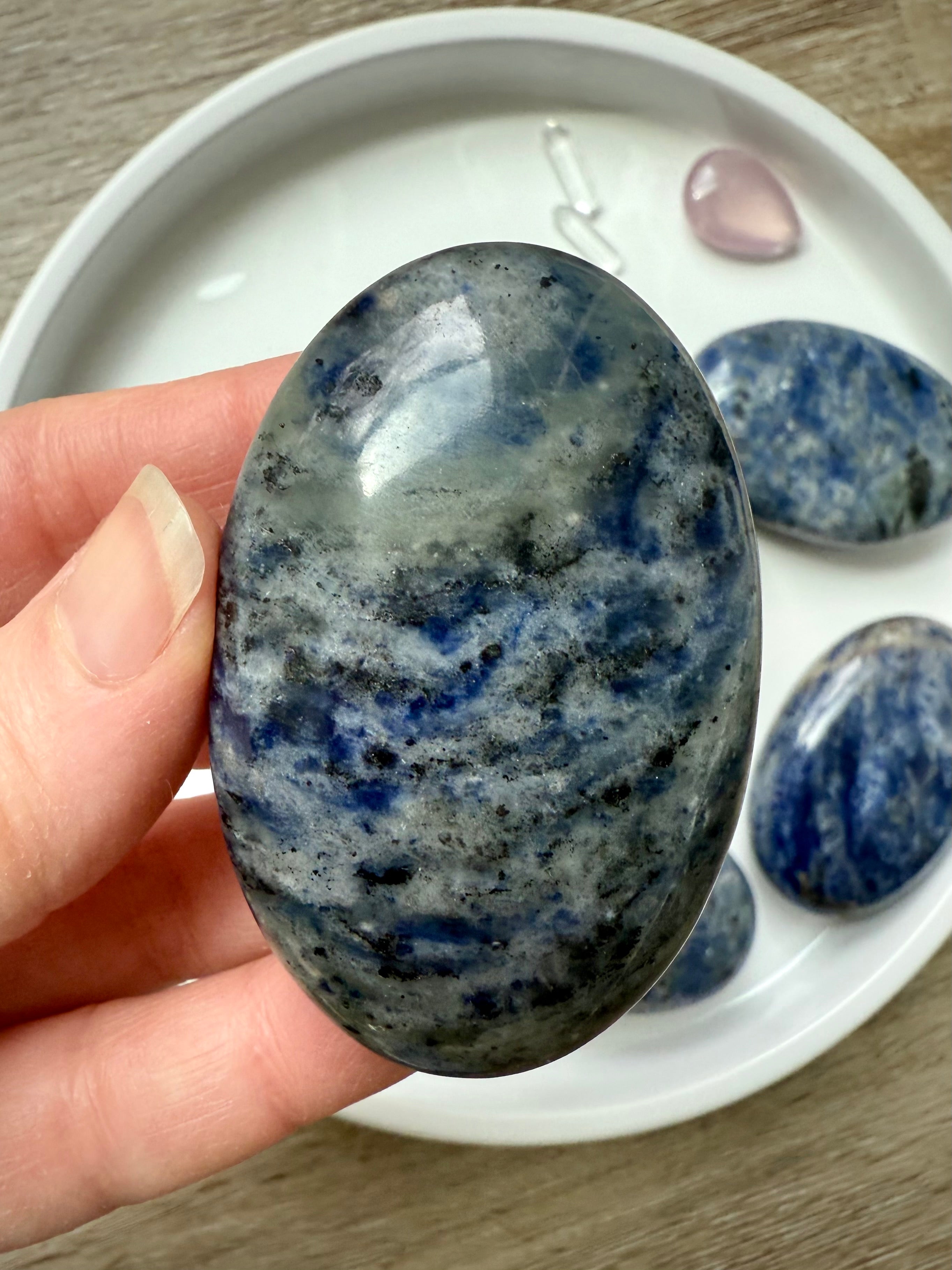 Close up picture of a high quality blue Sodalite Palm Stone held in my hand for scale