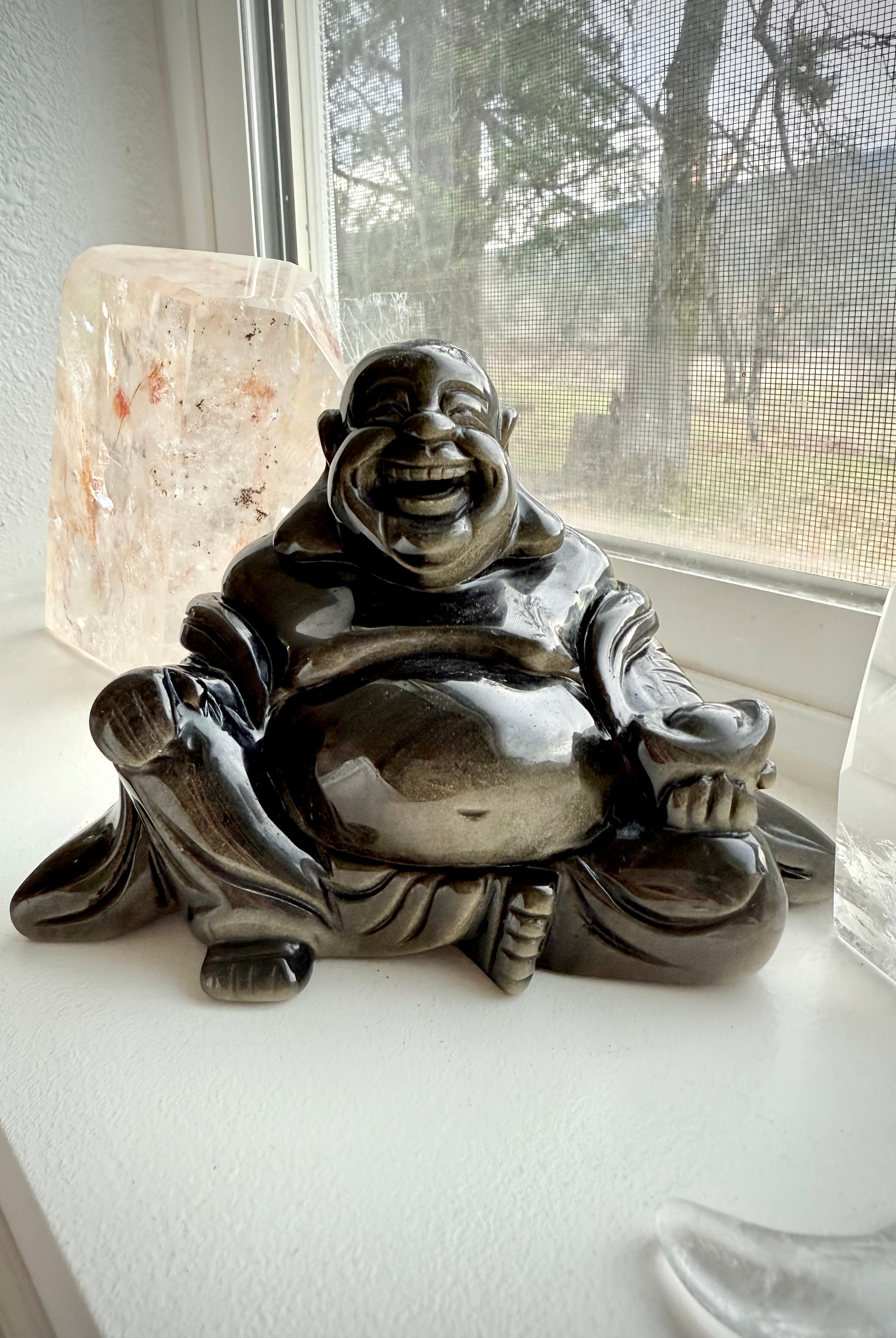 Golden Sheen Obsidian Buddha statue on windowsill with quartz and crystal moon – grounding altar decor for healing and spiritual balance